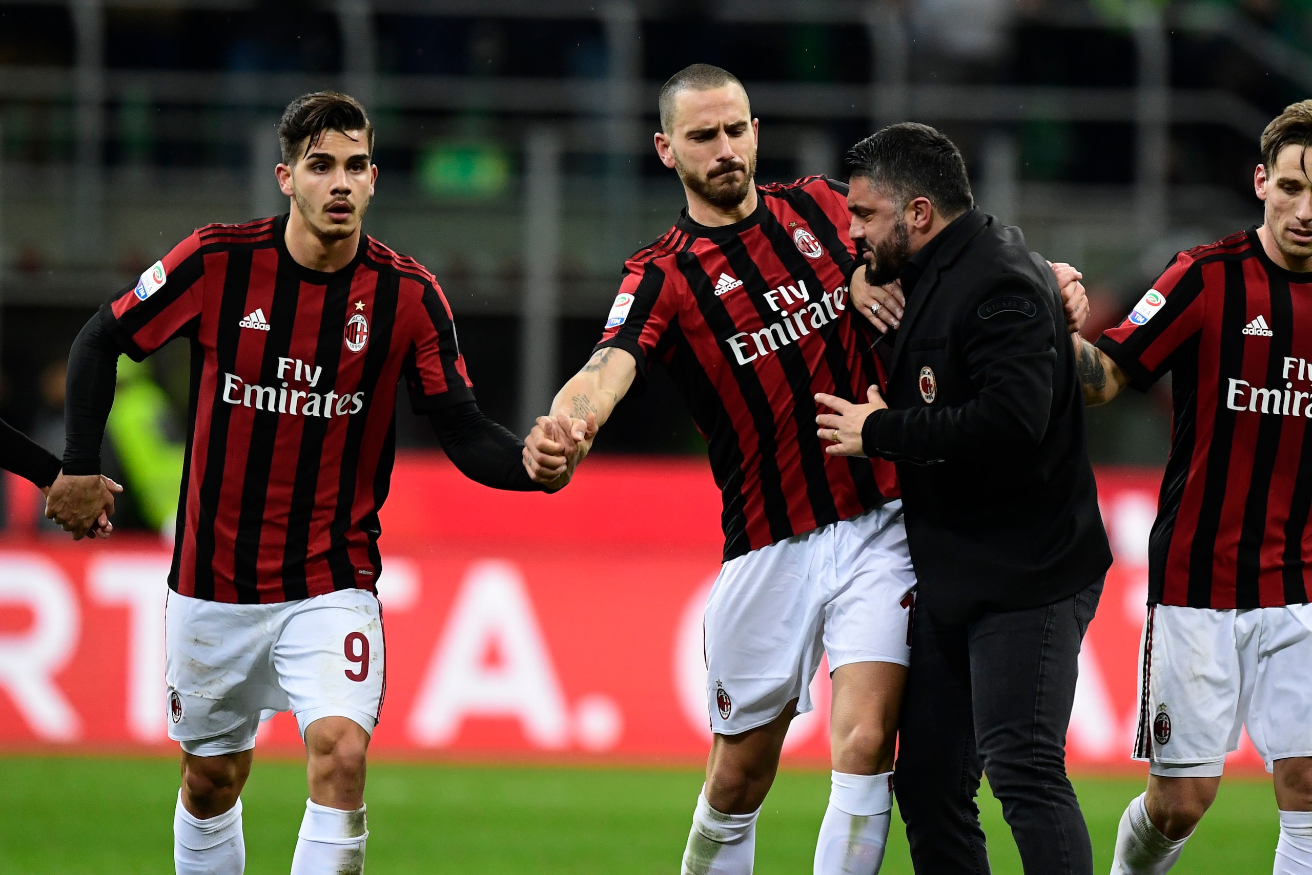 AC Milan's coach from Italy Gennaro Gattuso (black suit) celebrate with AC Milan's Captain Italian defender Leonardo Bonucci (2nd-L) and AC Milan's Portuguese forward Andre Silva (1st-L) after winning the Italian Serie A football match between AC Milan an