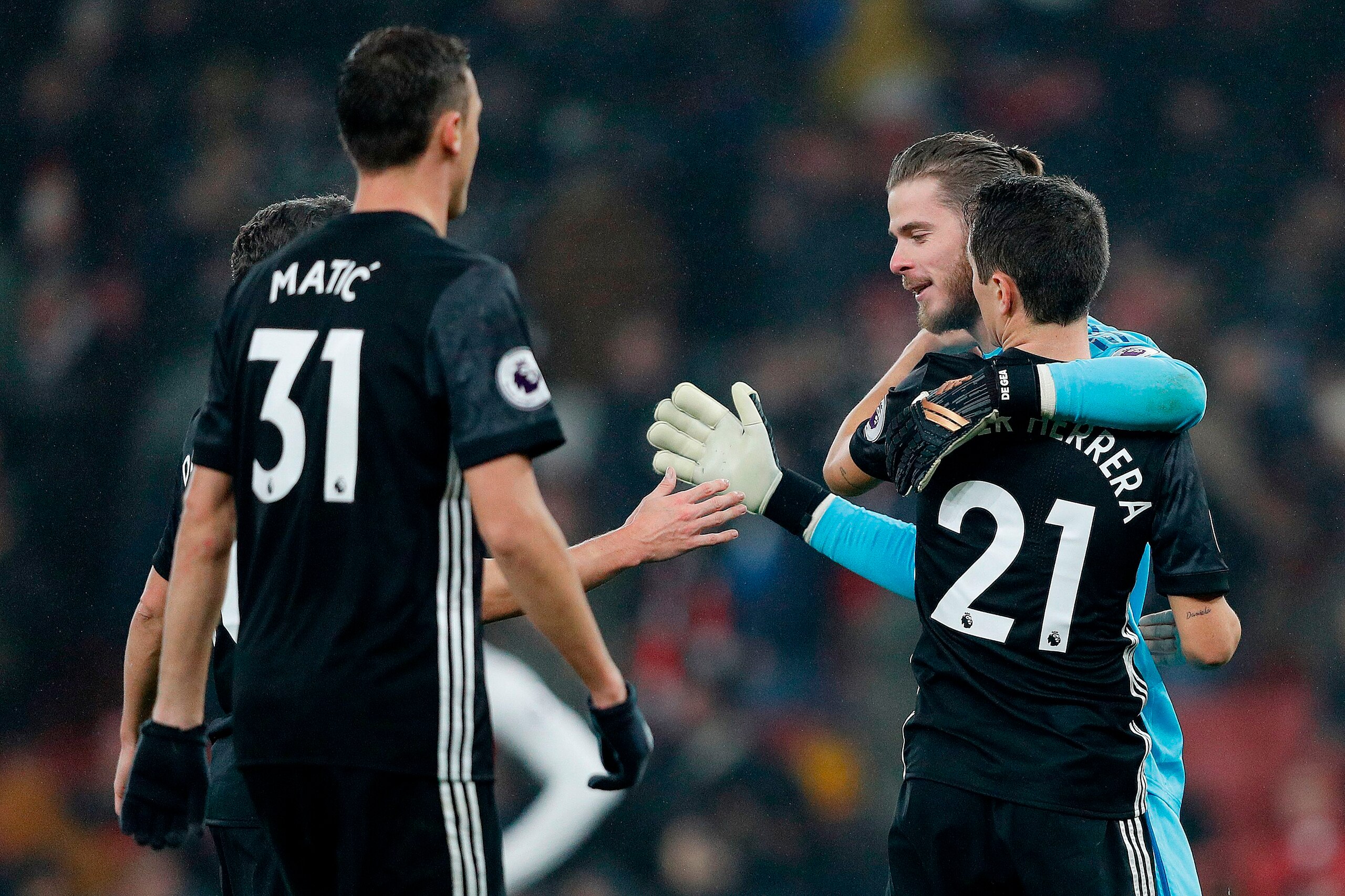Manchester United's Spanish goalkeeper David de Gea celebrates with Manchester United's Serbian midfielder Nemanja Matic (L) and Manchester United's Spanish midfielder Ander Herrera following the English Premier League football match between Arsenal and M