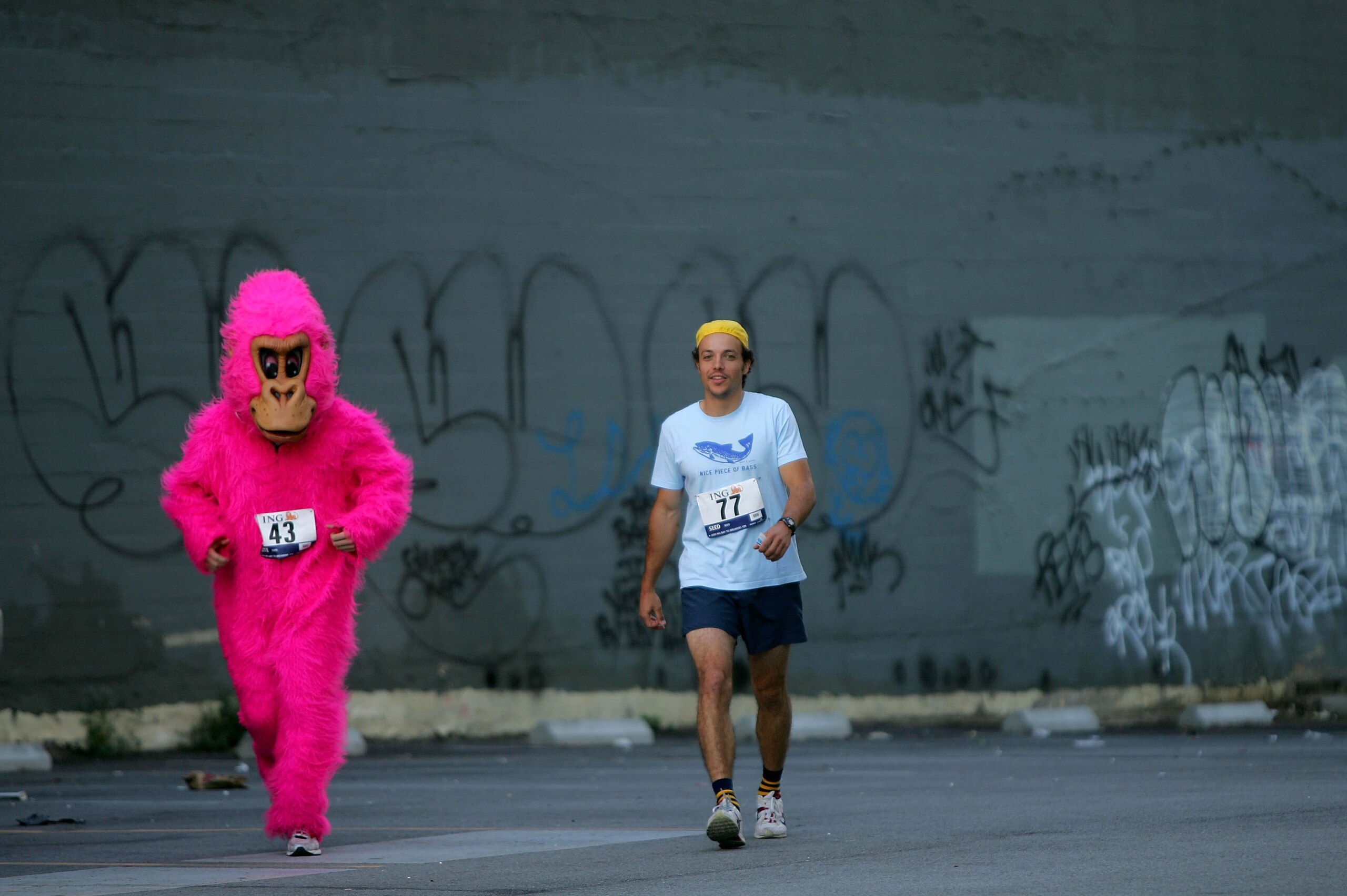 SAN FRANCISCO - MAY 17: Two participants, one in costume, walk through a parking lot to get to the start of the ING Bay to Breakers race May 17, 2009 in San Francisco, California. Now in its 98th year, the ING Bay to Breakers 12K is one of the world's l SAN FRANCISCO - MAY 17: Two participants, one in costume, walk through a parking lot to get to the start of the ING Bay to Breakers race May 17, 2009 in San Francisco, California. Now in its 98th year, the ING Bay to Breakers 12K is one of the world's l