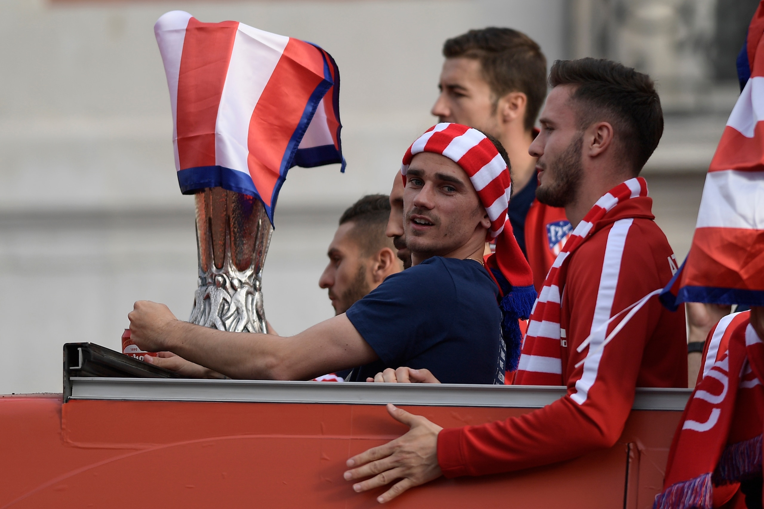 Atletico Madrid's French forward Antoine Griezmann stands with Atletico Madrid's Spanish midfielder Saul Niguez (R) aboard an open-top bus during a parade celebrating the team's Europa League victory at Puerta del Sol in Madrid on May 18, 2018. (Photo by 