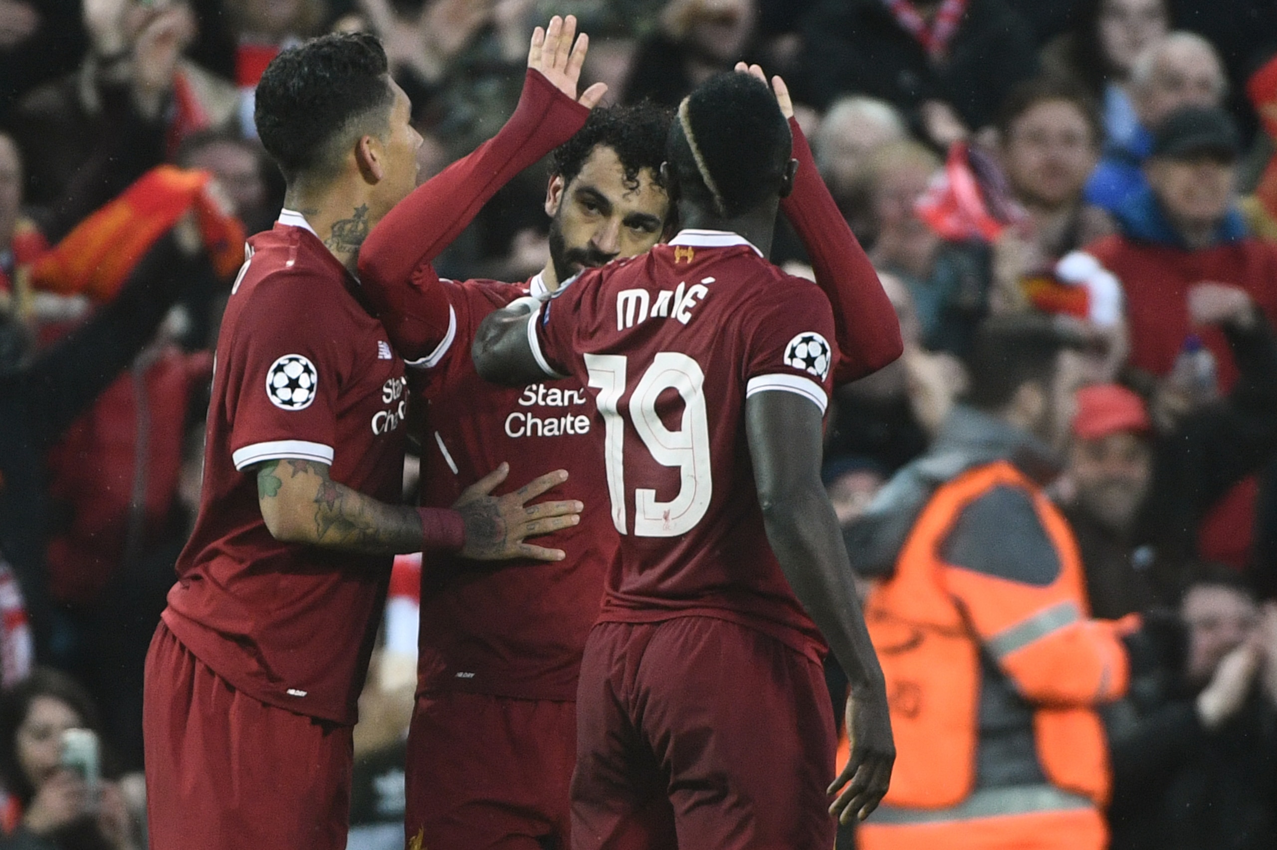 Liverpool's Egyptian midfielder Mohamed Salah (C) celebrates after scoring with Liverpool's Brazilian midfielder Roberto Firmino (L) and Liverpool's Senegalese midfielder Sadio Mane during the UEFA Champions League first leg semi-final football match betw