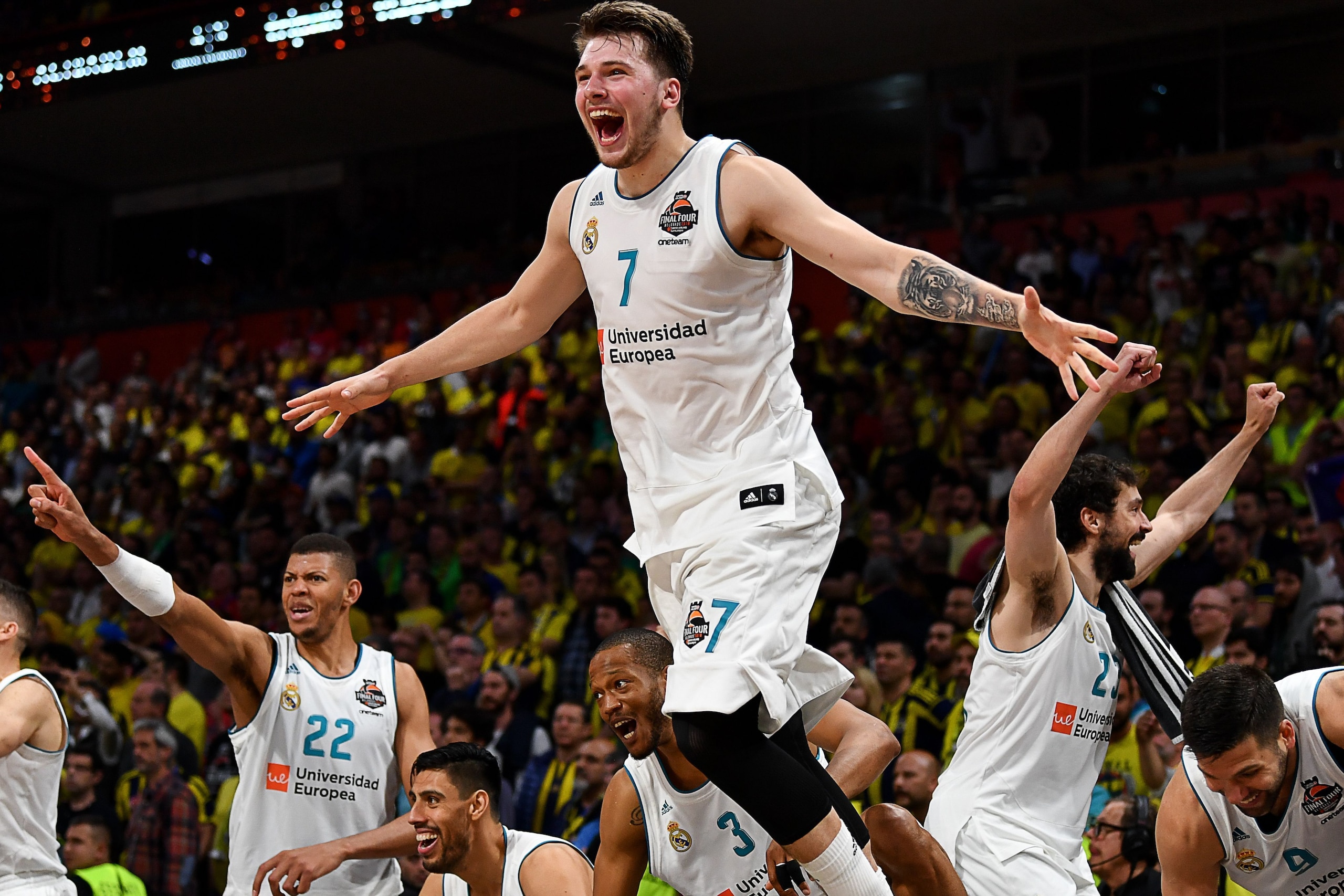 TOPSHOT - Real Madrid's Slovenian Luka Doncic (C-7) jumps over the barrier as the team celebrates their 85-80 win in the Euroleague Final Four finals basketball match between Real Madrid and Fenerbahce Dogus Istanbul at The Stark Arena in Belgrade on May 