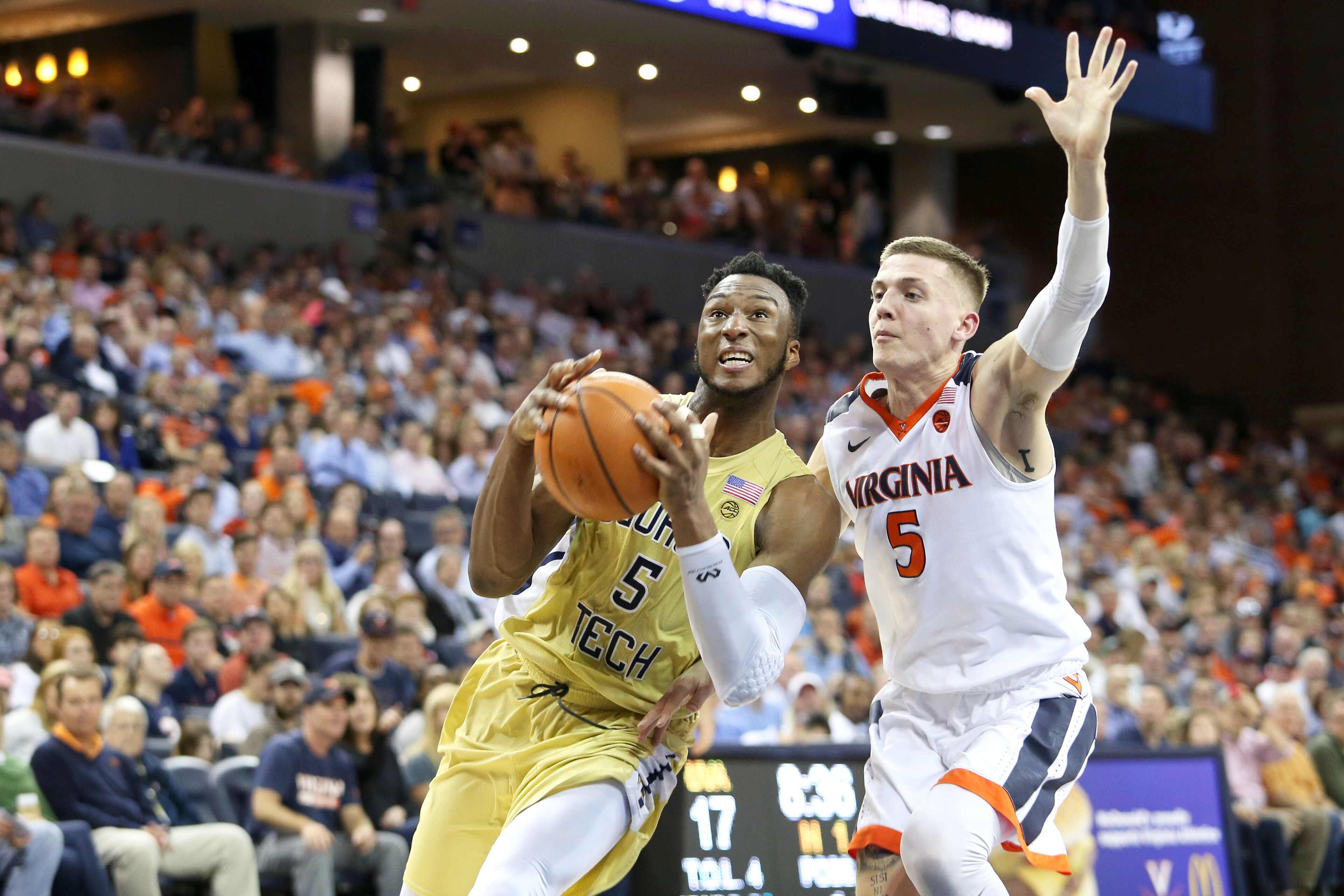 CHARLOTTESVILLE, VA - FEBRUARY 21: Josh Okogie #5 of the Georgia Tech Yellow Jackets drives past Kyle Guy #5 of the Virginia Cavaliers in the first half during a game at John Paul Jones Arena on February 21, 2018 in Charlottesville, Virginia. Virginia def