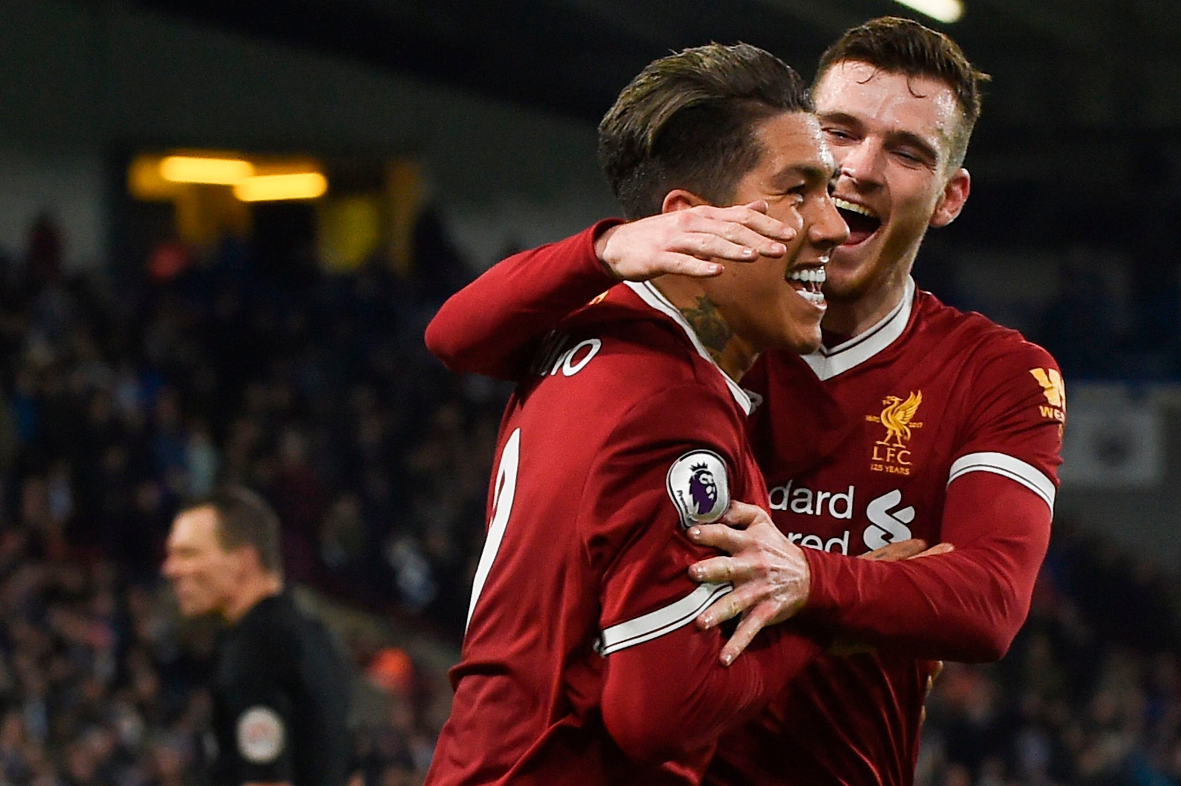 Liverpool's Brazilian midfielder Roberto Firmino (L) celebrates scoring their second goal with Liverpool's Scottish defender Andrew Robertson (R)  during the English Premier League football match between Huddersfield Town and Liverpool at the John Smith's