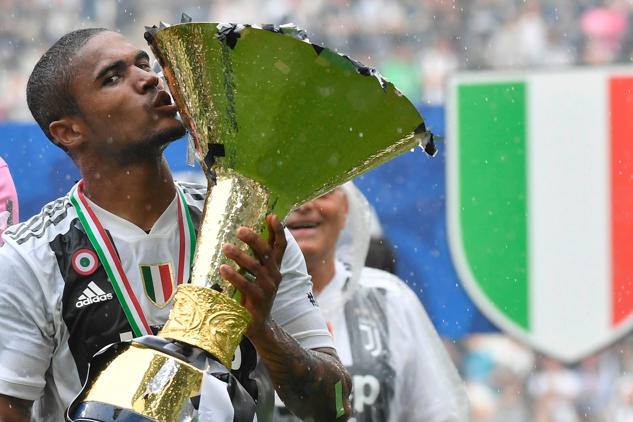 Juventus' forward from Brazil Douglas Costa kisses the trophy during the victory ceremony following the Italian Serie A last football match of the season Juventus versus Verona, on May 19, 2018 at the Allianz Stadium in Turin. Juventus won their 34th Seri
