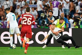 A pitch invader is tackled as Ronaldo (L) was closing in on goal during the UEFA Champions League final football match between Liverpool and Real Madrid at the Olympic Stadium in Kiev, Ukraine on May 26, 2018. - Real Madrid won the game 3-1. (Photo by Pau