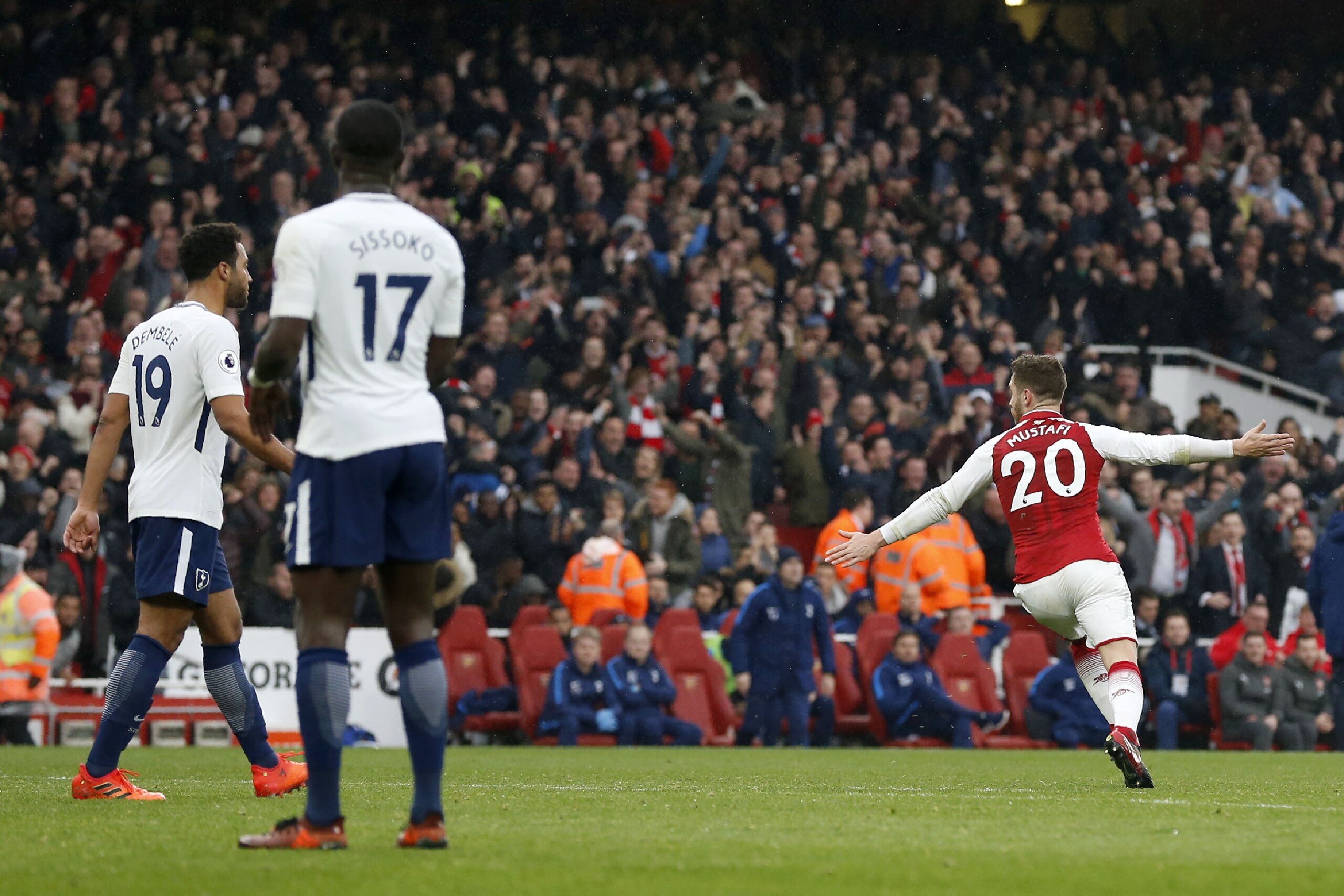 Arsenal's German defender Shkodran Mustafi (R) celebrates scoring the team's first goal as Tottenham Hotspur's Belgian midfielder Mousa Dembele (L) and Tottenham Hotspur's French midfielder Moussa Sissoko look on during the English Premier League football