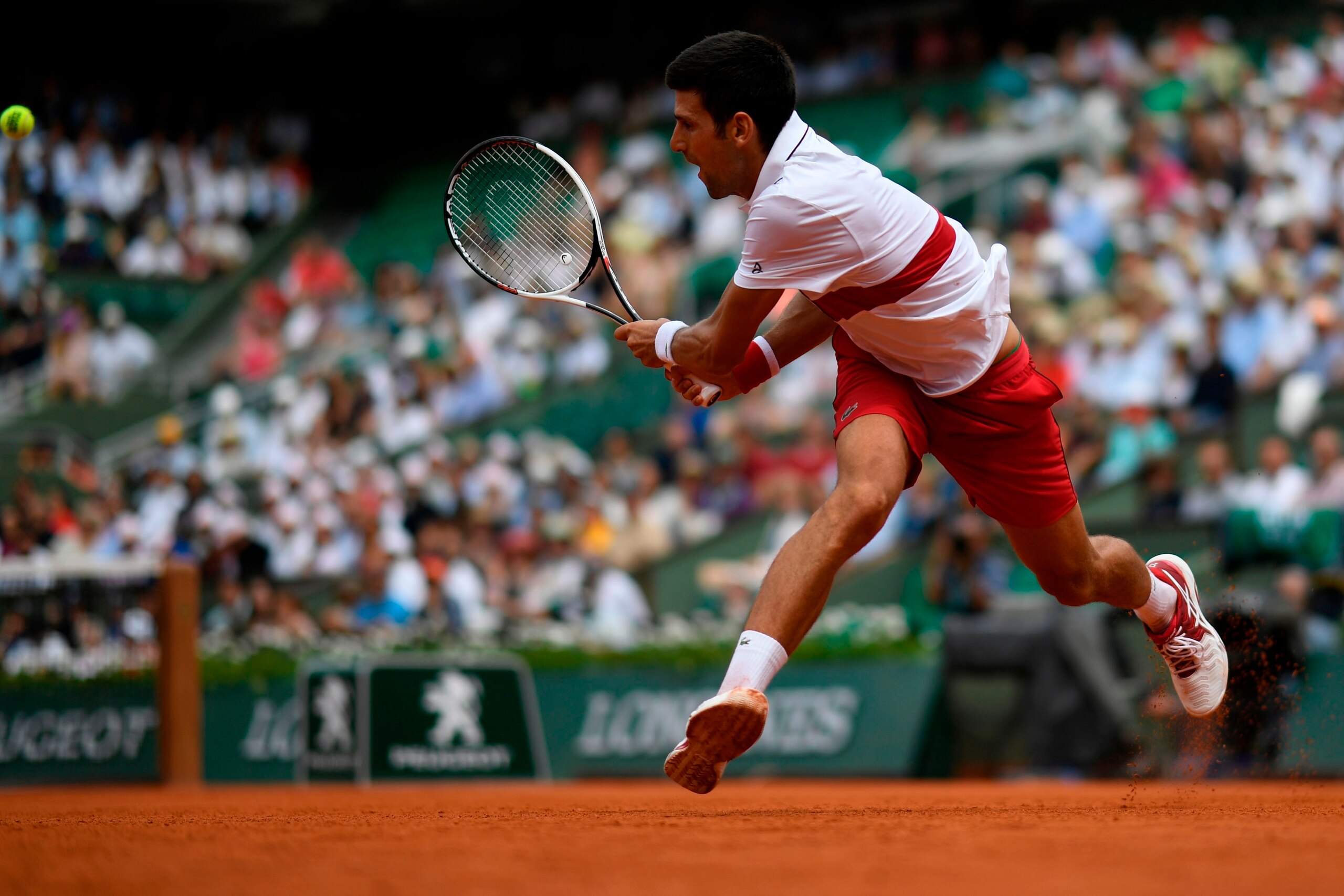 TOPSHOT - Serbia's Novak Djokovic plays a return to Brazil's Rogerio Dutra Silva during their men's singles first round match on day two of The Roland Garros 2018 French Open tennis tournament in Paris on May 28, 2018. (Photo by CHRISTOPHE SIMON / AFP)   