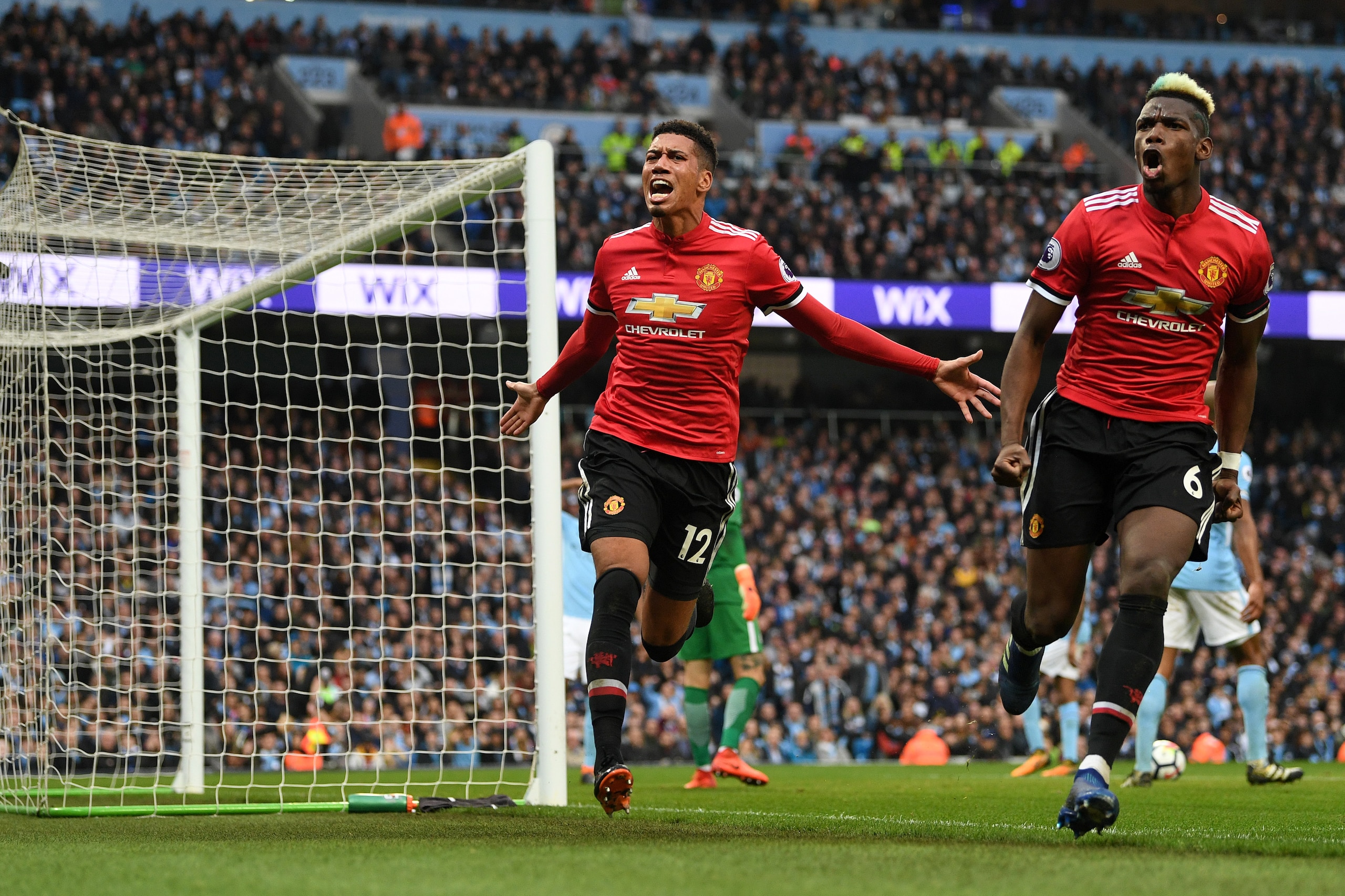 MANCHESTER, ENGLAND - APRIL 07:  Chris Smalling of Manchester United celebrates scoring his side's third goal with Paul Pogba during the Premier League match between Manchester City and Manchester United at Etihad Stadium on April 7, 2018 in Manchester, E