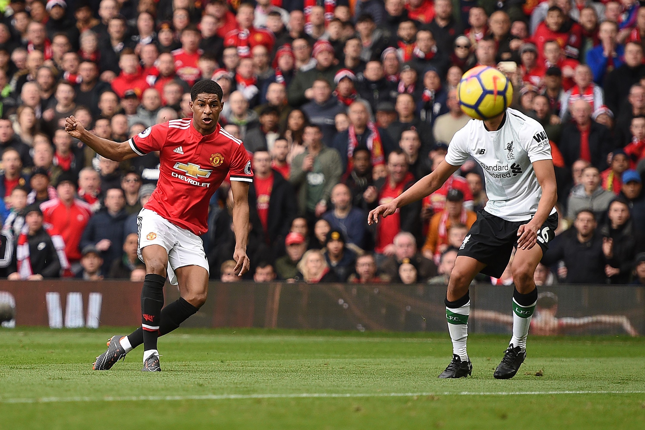 Manchester United's English striker Marcus Rashford (L) scores the opening goal during the English Premier League football match between Manchester United and Liverpool at Old Trafford in Manchester, north west England, on March 10, 2018. / AFP PHOTO / Ol