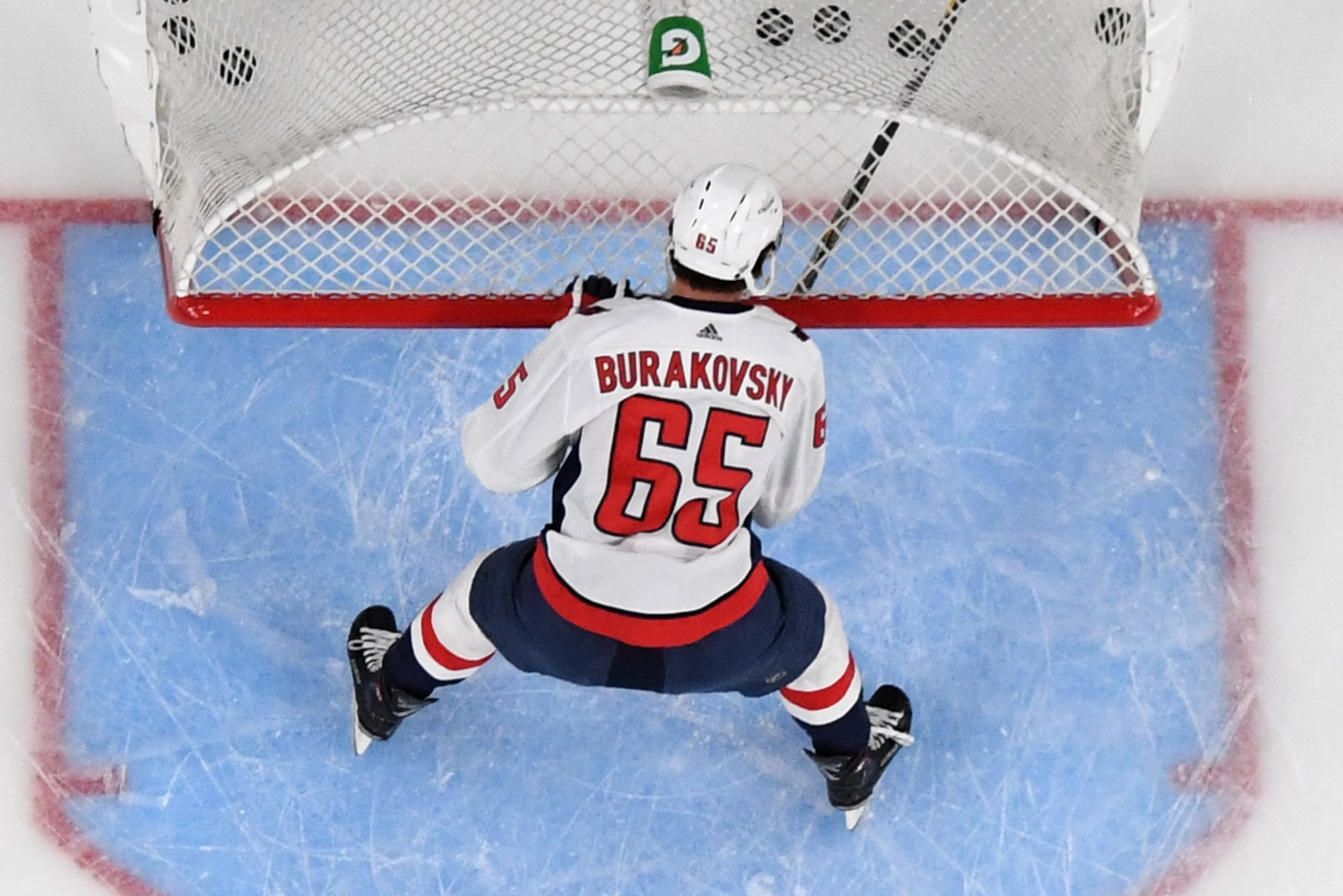 LAS VEGAS, NV - MAY 30: Andre Burakovsky #65 of the Washington Capitals clears pucks from a net during warmups before Game Two of the 2018 NHL Stanley Cup Final at T-Mobile Arena on May 30, 2018 in Las Vegas, Nevada. The Capitals defeated the Golden Knig LAS VEGAS, NV - MAY 30: Andre Burakovsky #65 of the Washington Capitals clears pucks from a net during warmups before Game Two of the 2018 NHL Stanley Cup Final at T-Mobile Arena on May 30, 2018 in Las Vegas, Nevada. The Capitals defeated the Golden Knig