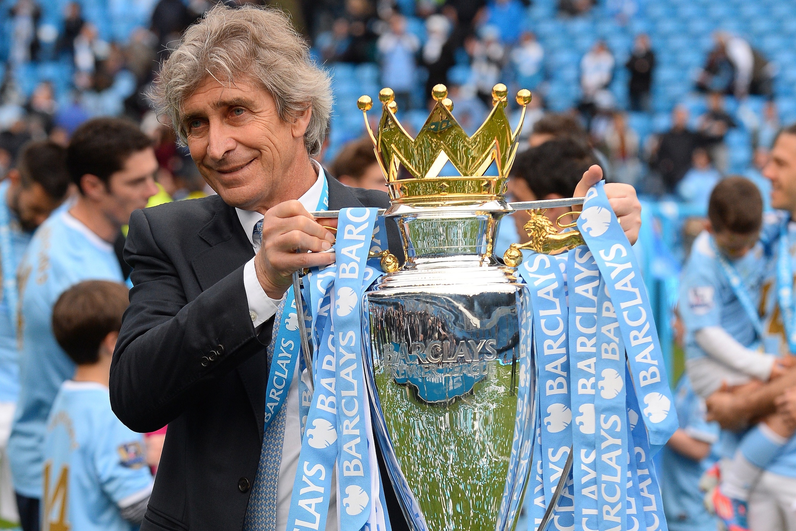 Manchester City's Chilean manager Manuel Pellegrini poses for pictures with the Premiership trophy after his team's victory during the English Premier League football match between Manchester City and West Ham United at the Etihad Stadium in Manchester on