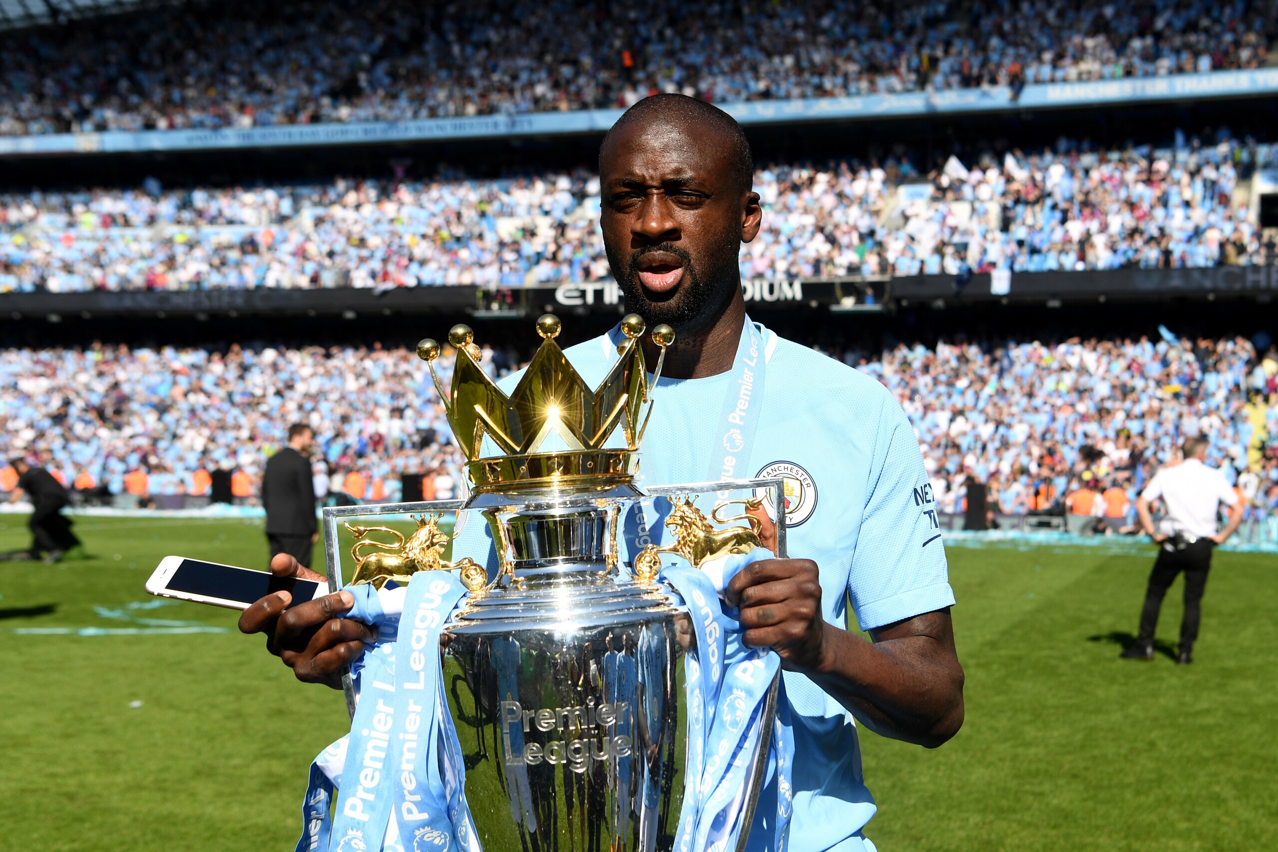 MANCHESTER, ENGLAND - MAY 06: Yaya Toure of Manchester City celebrates with The Premier League Trophy after the Premier League match between Manchester City and Huddersfield Town at Etihad Stadium on May 6, 2018 in Manchester, England.  (Photo by Michael 