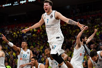 TOPSHOT - Real Madrid's Slovenian Luka Doncic (C-7) jumps over the barrier as the team celebrates their 85-80 win in the Euroleague Final Four finals basketball match between Real Madrid and Fenerbahce Dogus Istanbul at The Stark Arena in Belgrade on May 