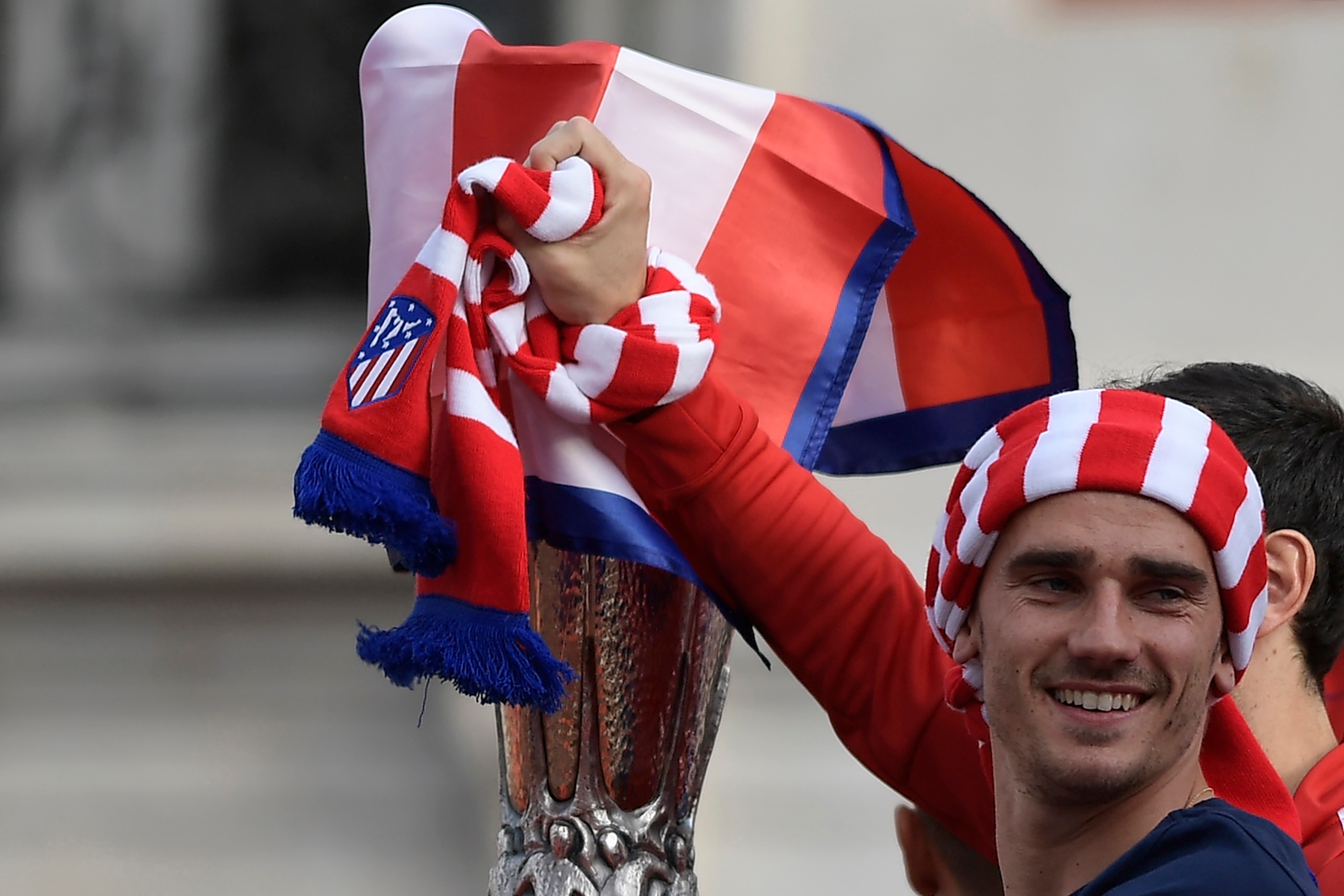 Atletico Madrid's French forward Antoine Griezmann stands next to the trophy aboard an open-top bus during a parade celebrating the team's Europa League victory at Puerta del Sol in Madrid on May 18, 2018. (Photo by OSCAR DEL POZO / AFP)        (Photo cre