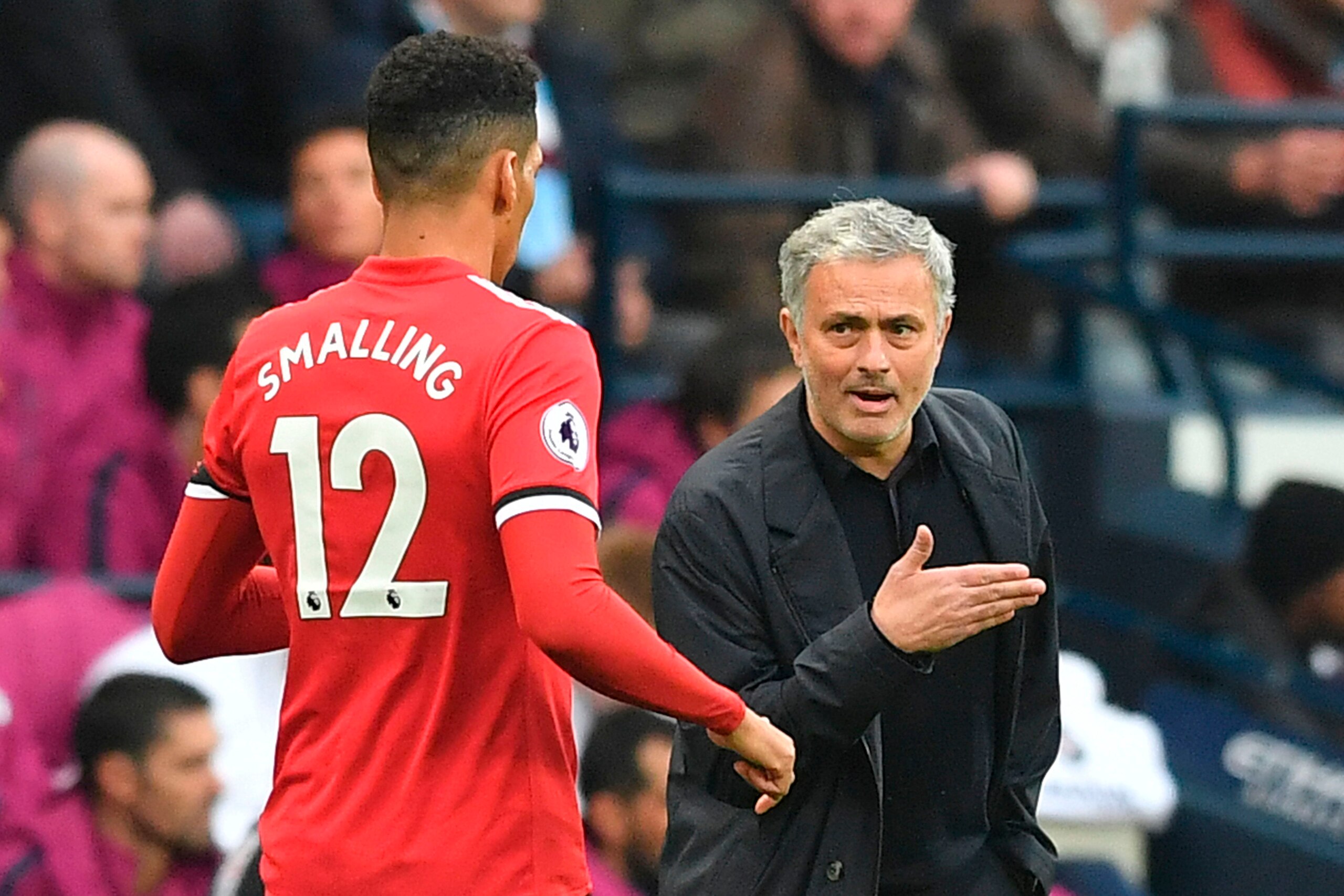 Manchester United's Portuguese manager Jose Mourinho (R) has a word with Manchester United's English defender Chris Smalling (L) on the touchline during the English Premier League football match between Manchester City and Manchester United at the Etihad 
