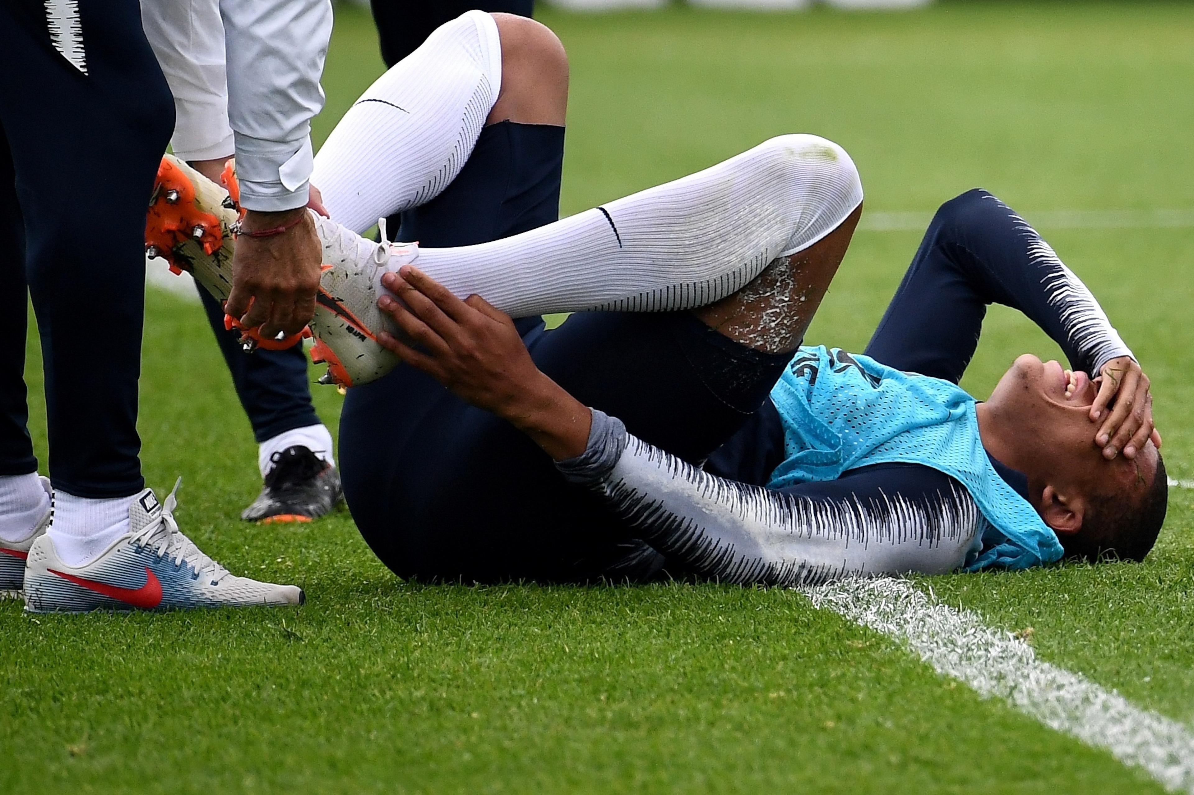 TOPSHOT - France's forward Kylian Mbappe (C) reacts after getting injured during a training session at the Glebovets stadium in Istra, on June 12, 2018, ahead of the Russia 2018 World Cup football tournament. (Photo by FRANCK FIFE / AFP)        (Photo cre