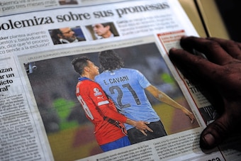 The front page of an Uruguayan newspaper shows on June 25, 2015 in Montevideo a picture of Chile's football team defender Gonzalo Jara provoking Uruguay's Edinson Cavani during their Copa America 2015 quarterfinals football match in Santiago.  Cavani was 