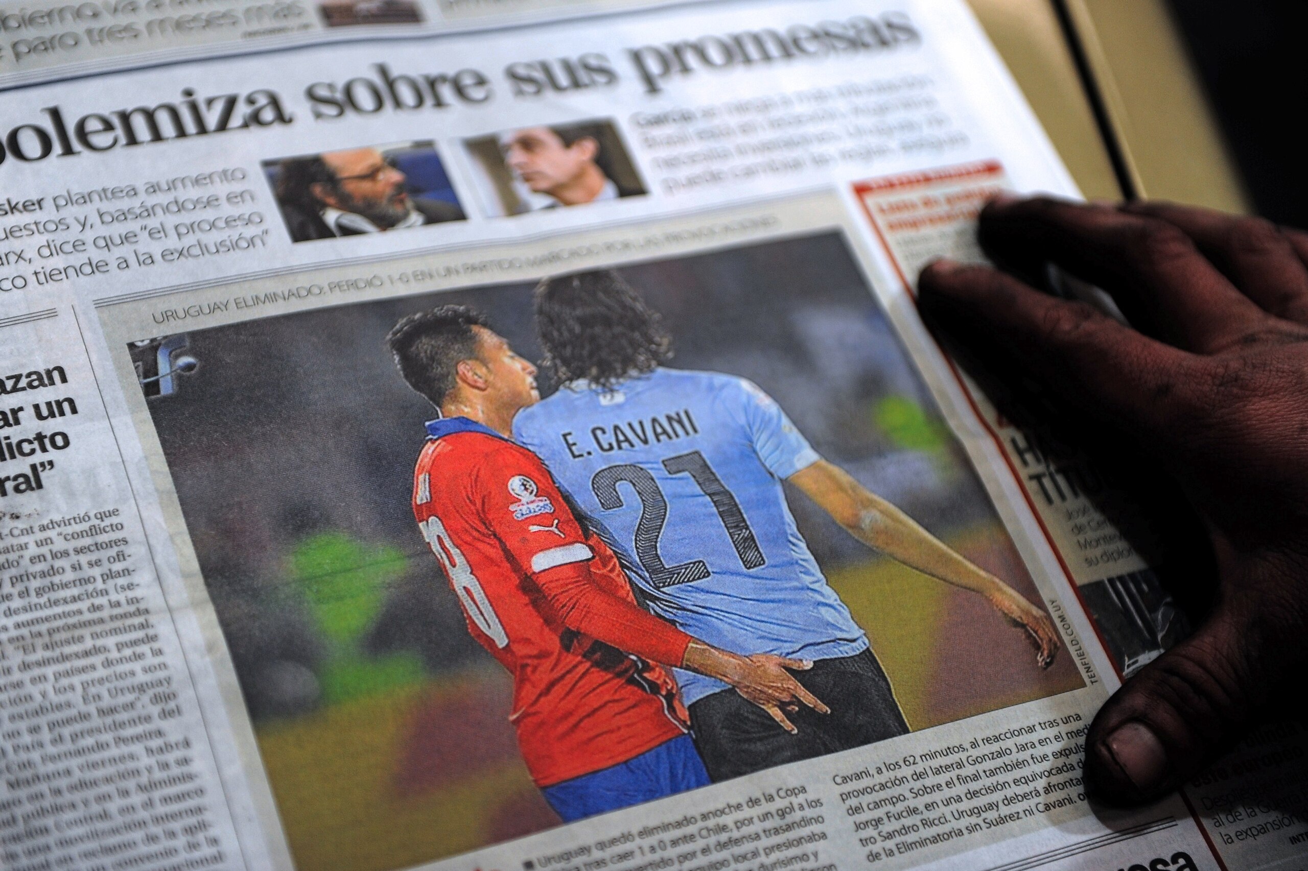 The front page of an Uruguayan newspaper shows on June 25, 2015 in Montevideo a picture of Chile's football team defender Gonzalo Jara provoking Uruguay's Edinson Cavani during their Copa America 2015 quarterfinals football match in Santiago.  Cavani was 
