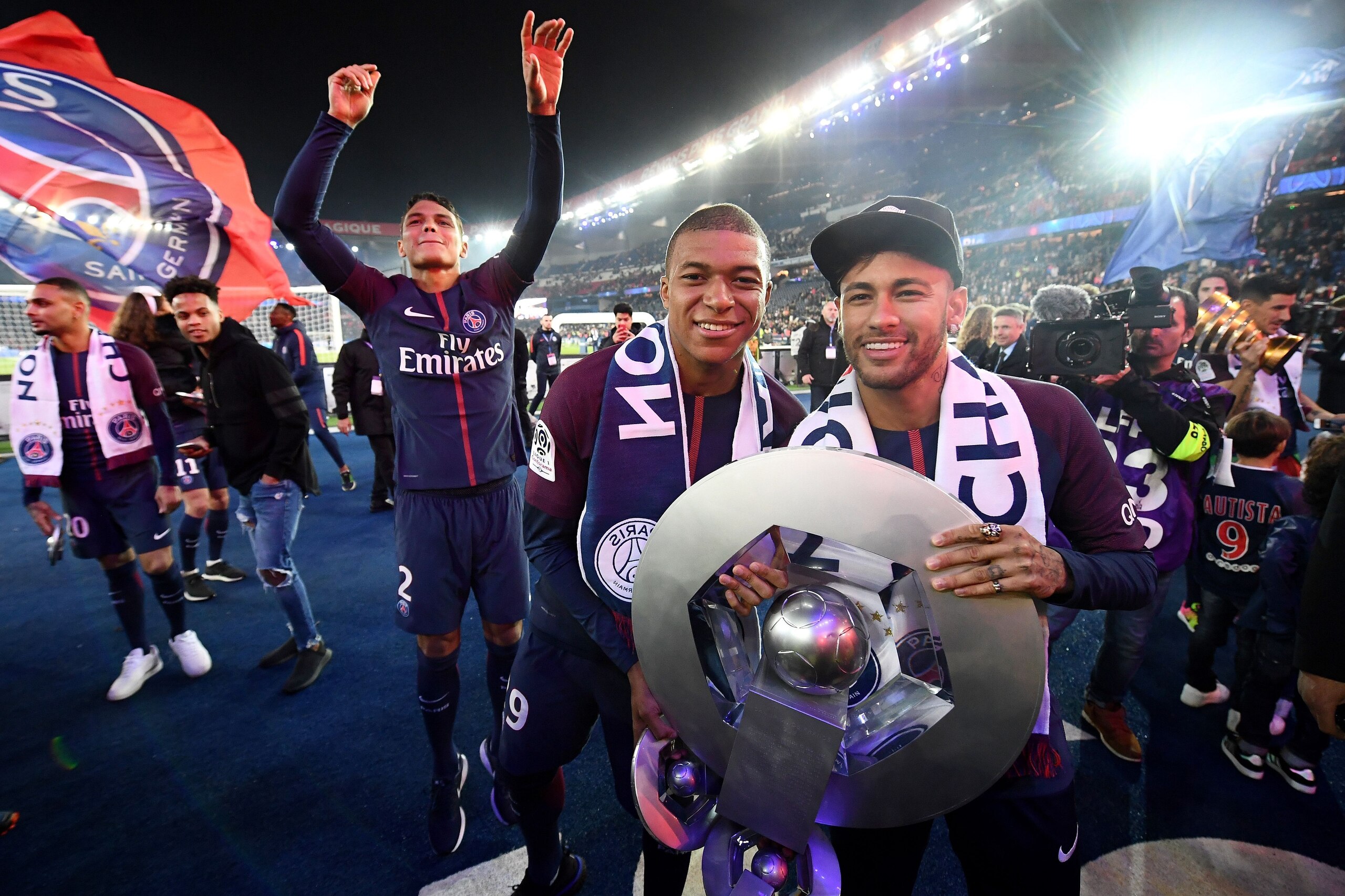Paris Saint-Germain's French forward Kylian MBappe (L) and Paris Saint-Germain's Brazilian forward Neymar pose with a trophy after winning the French L1 title at the end of the French L1 football match Paris Saint-Germain (PSG) vs Rennes on May 12, 2018 a