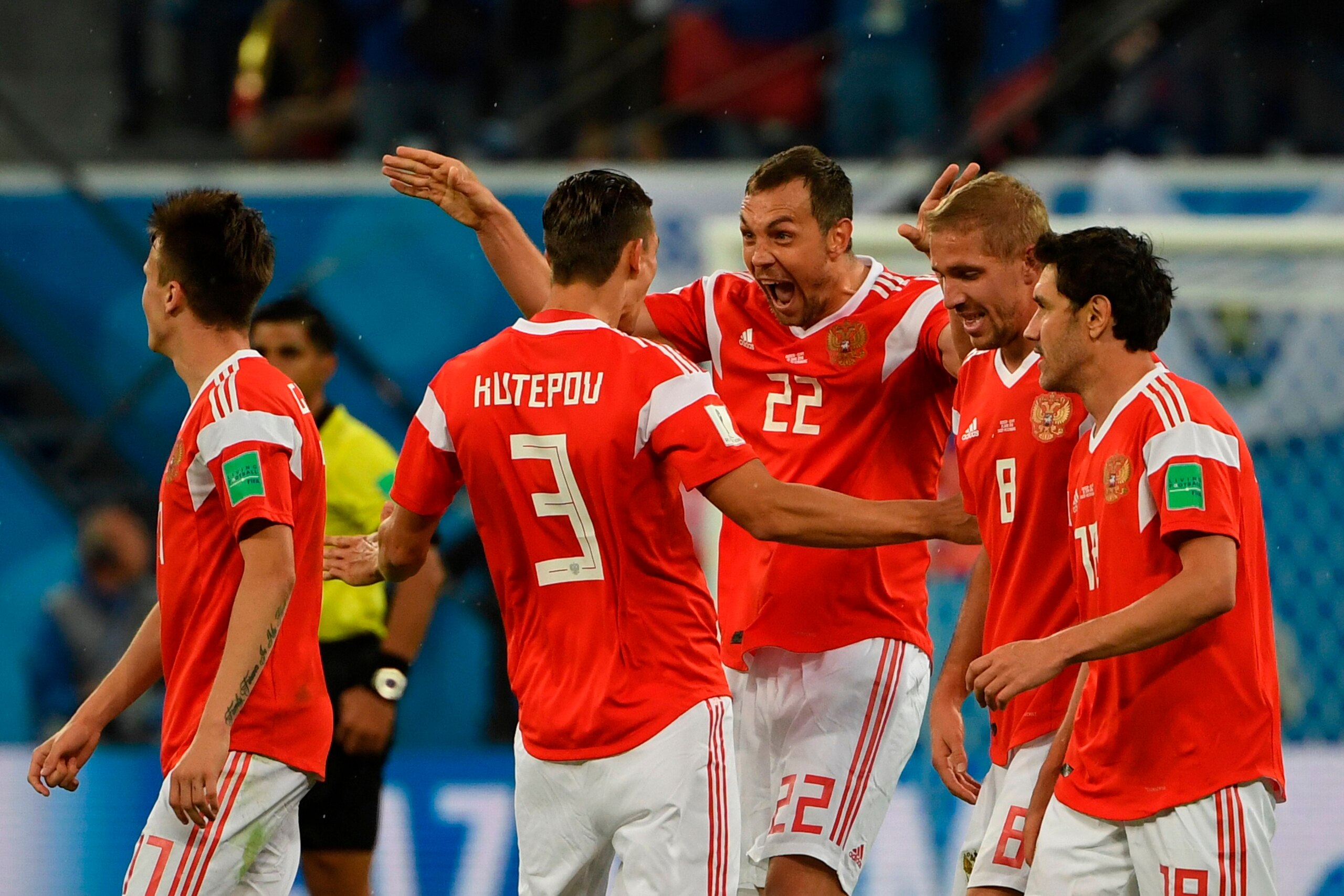 Russia's forward Artem Dzyuba (C) celebrates scoring the 3-0 goal with his teammates during the Russia 2018 World Cup Group A football match between Russia and Egypt at the Saint Petersburg Stadium in Saint Petersburg on June 19, 2018. (Photo by Paul ELLI