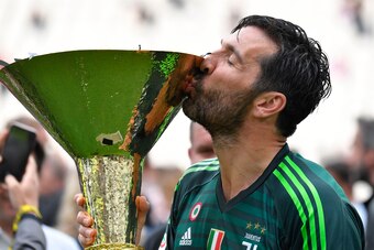 TOPSHOT - Juventus' goalkeeper from Italy Gianluigi Buffon kisses the trophy during the victory ceremony following the Italian Serie A last football match of the season Juventus versus Verona, on May 19, 2018 at the Allianz Stadium in Turin. Juventus won 