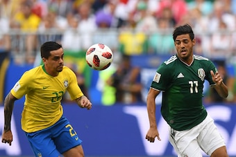 Brazil's defender Fagner (L) eyes the ball as he vies for it with Mexico's forward Carlos Vela (R) during the Russia 2018 World Cup round of 16 football match between Brazil and Mexico at the Samara Arena in Samara on July 2, 2018. (Photo by MANAN VATSYAY