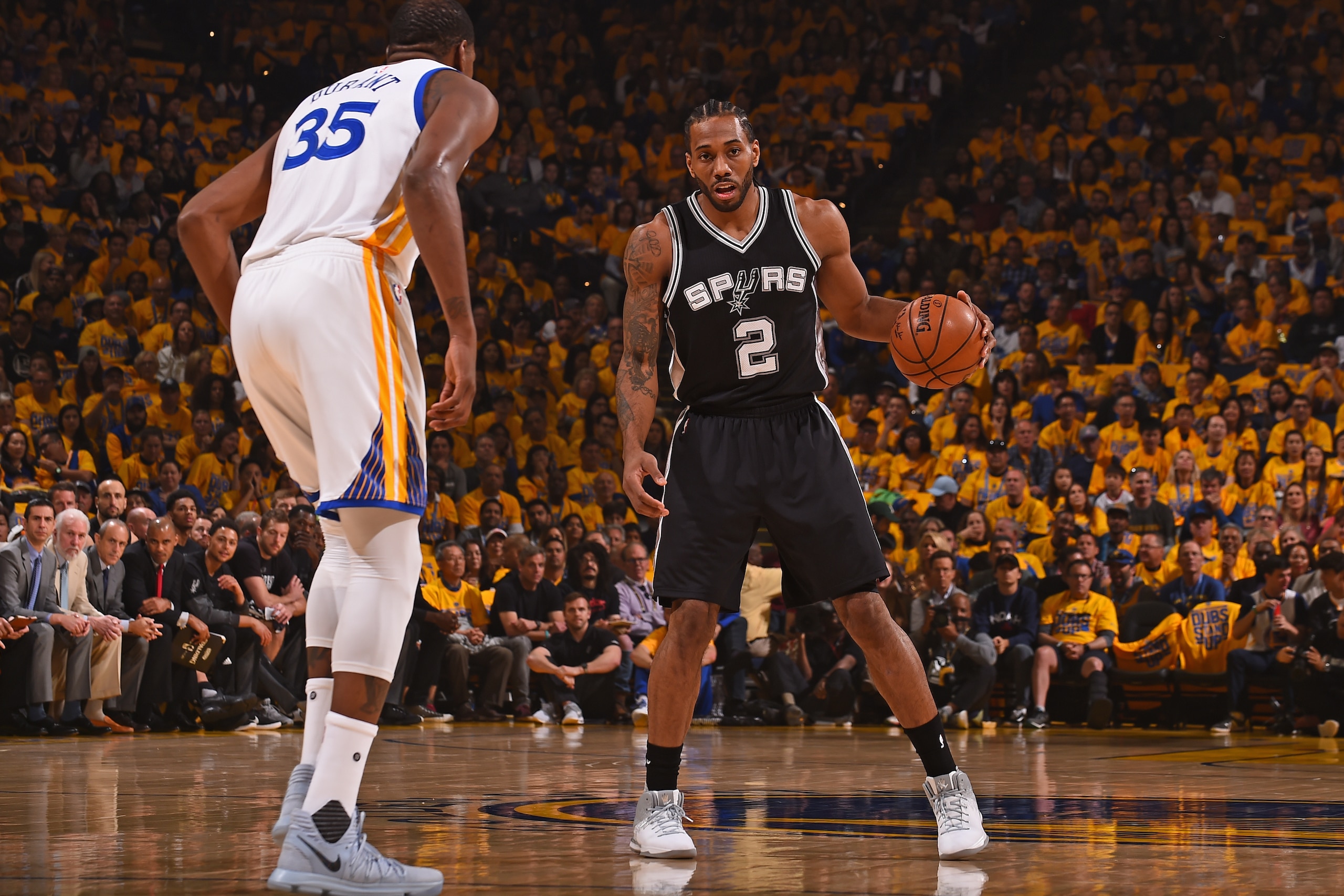 OAKLAND, CA - MAY 14: Kawhi Leonard #2 of the San Antonio Spurs dribbles the ball while guarded by Kevin Durant #35 of the Golden State Warriors in Game One of the Western Conference Finals during the 2017 NBA Playoffs on May 14, 2017 at ORACLE Arena in OAKLAND, CA - MAY 14: Kawhi Leonard #2 of the San Antonio Spurs dribbles the ball while guarded by Kevin Durant #35 of the Golden State Warriors in Game One of the Western Conference Finals during the 2017 NBA Playoffs on May 14, 2017 at ORACLE Arena in