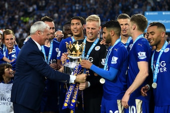 LEICESTER, ENGLAND - MAY 07:  Claudio Ranieri Manager of Leicester City passes the Premier League Trophy to Kasper Schmeichel and Riyad Mahrez as players and staffs celebrate the season champions after the Barclays Premier League match between Leicester C