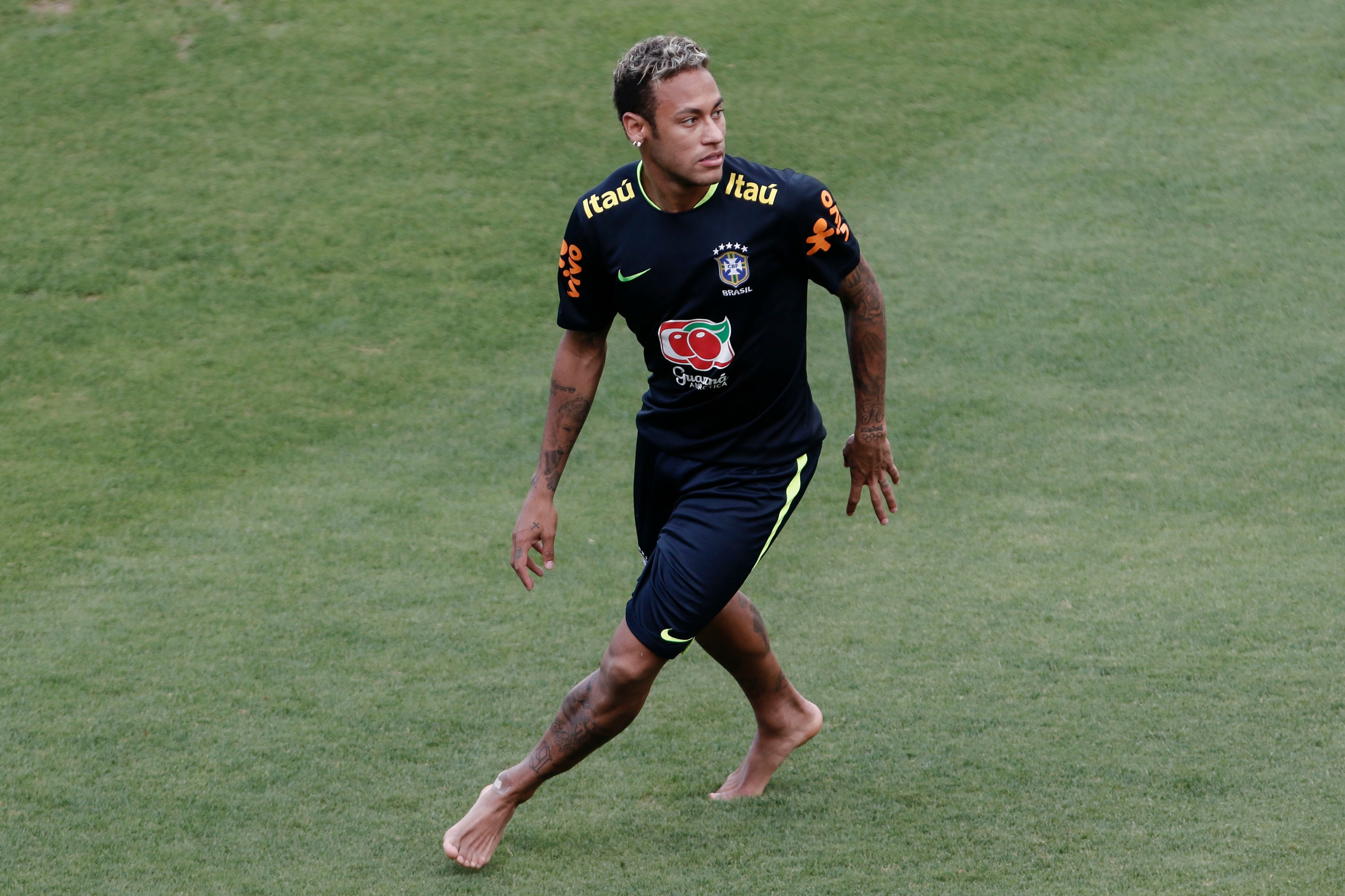 Brazil's Neymar stands barefoot on the pitch during a training session at the Sao Paulo FC training center, in Sao Paulo, Brazil, on October 6, 2017 ahead of their World Cup qualifier match against Chile next October 10. / AFP PHOTO / Miguel SCHINCARIOL  