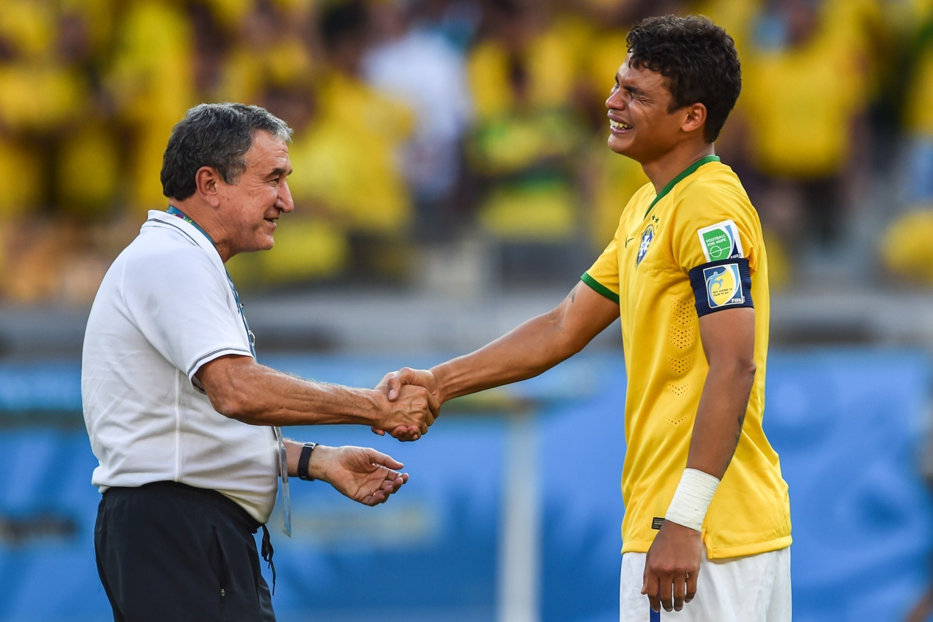 Brazil's Thiago Silva (R) reacts with coach assistant Carlos Alberto Parreira at the end of the Round of 16 football match between Brazil and Chile at The Mineirao Stadium in Belo Horizonte during the 2014 FIFA World Cup on June 28, 2014. AFP PHOTO / GUST
