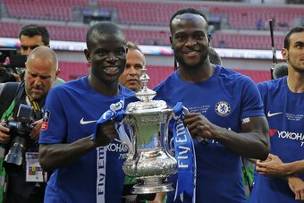 Chelsea's French midfielder N'Golo Kante (L) and Chelsea's Nigerian midfielder Victor Moses pose with the trophy as Chelsea's players celebrate their win on the pitch after the English FA Cup final football match between Chelsea and Manchester United at W
