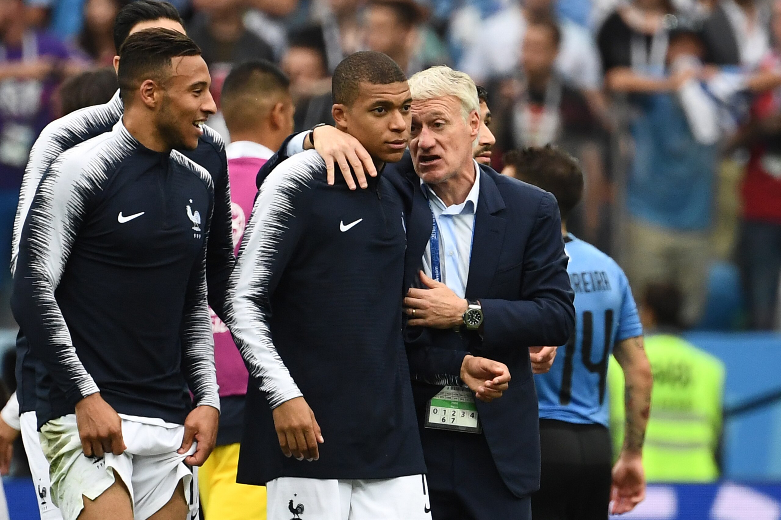 France's coach Didier Deschamps (R) talks with France's forward Kylian Mbappe (C) at the end of the Russia 2018 World Cup quarter-final football match between Uruguay and France at the Nizhny Novgorod Stadium in Nizhny Novgorod on July 6, 2018. (Photo by 