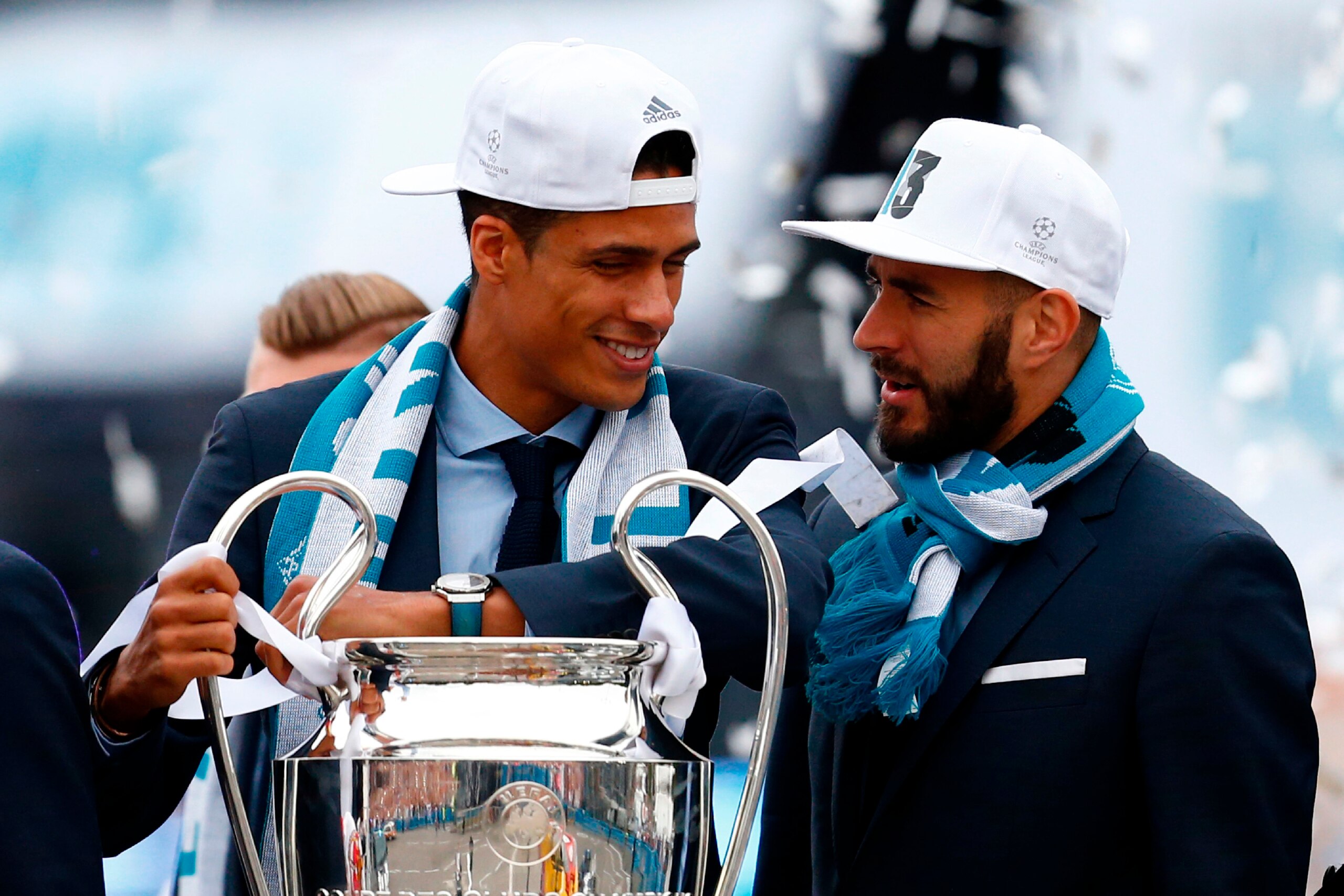 (FromL) Real Madrid's French defender Raphael Varane and Real Madrid's French forward Karim Benzema celebrate at Cibeles square in Madrid on May 27, 2018  after winning their third Champions League title in a row in Kiev. (Photo by BENJAMIN CREMEL / AFP) 