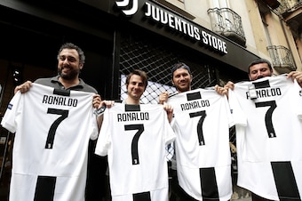 TOPSHOT - Juventus' supporters show their Cristiano Ronaldo's Juventus official Jerseys in front of the Juventus store on July 10, 2018 in Turin after Real Madrid announced today the transfer of Ronaldo to Italy's Juventus, with the Portuguese superstar s
