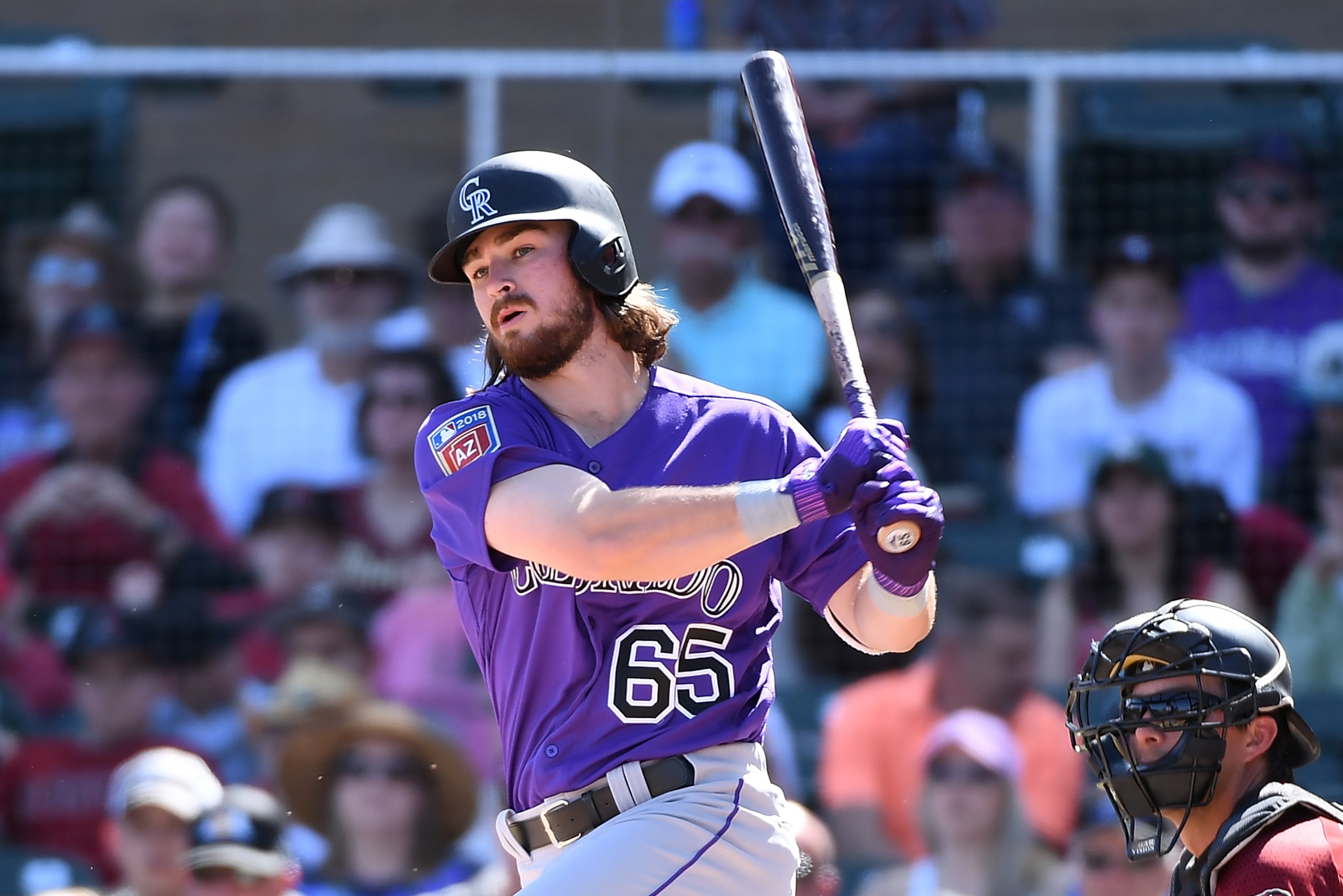 SCOTTSDALE, AZ - MARCH 12:  Brendan Rodgers #65 of the Colorado Rockies follows through on a swing during a spring training game against the Arizona Diamondbacks at Salt River Fields at Talking Stick on March 12, 2018 in Scottsdale, Arizona.  (Photo by No