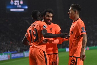 Liverpool's Senegalese midfielder Sadio Mane (L) celebrates with Liverpool's Egyptian midfielder Mohamed Salah and Liverpool's Brazilian midfielder Roberto Firmino (R) after scoring their third goal during the UEFA Champions League round of sixteen first 