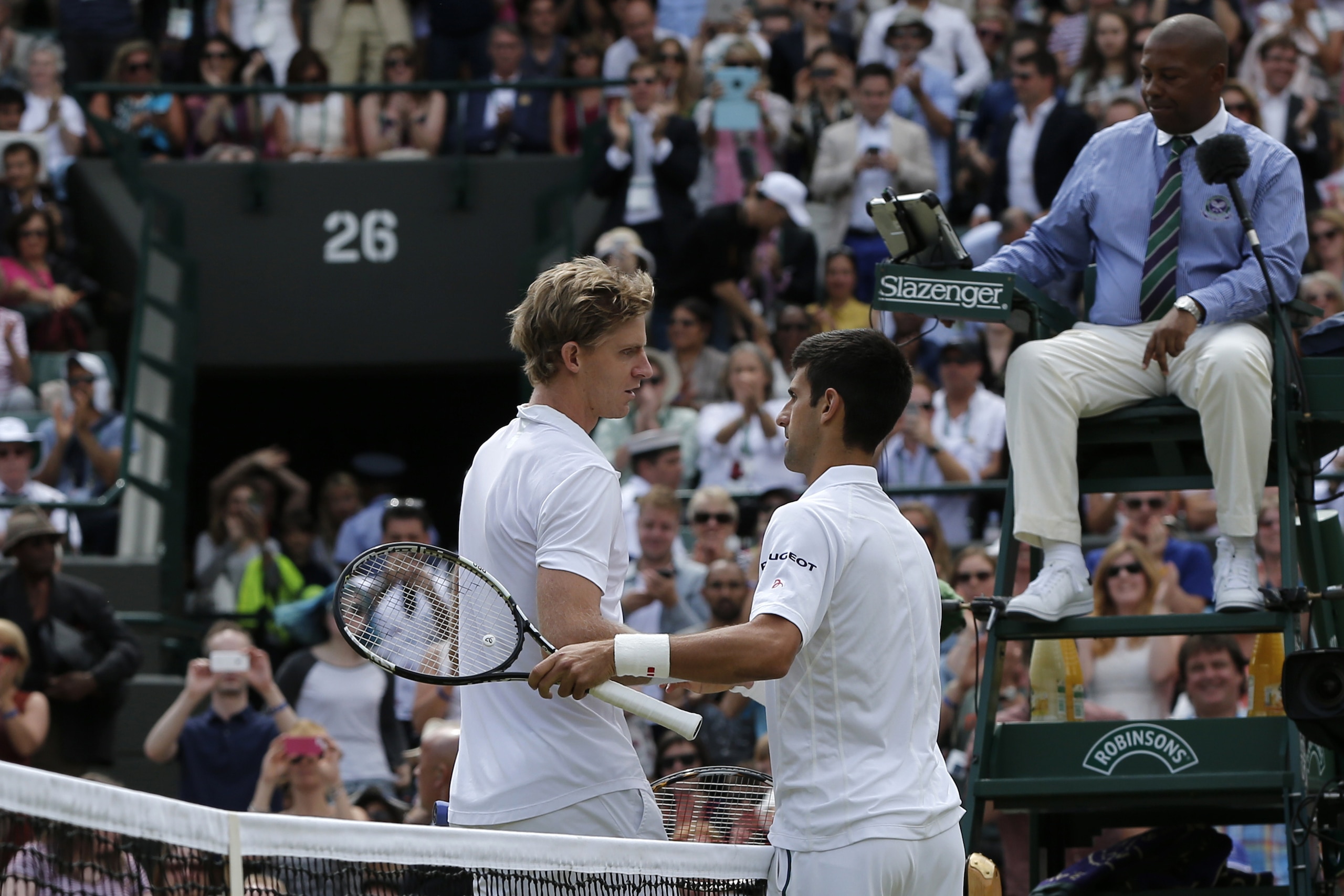 Serbia's Novak Djokovic (R) shakes hands with South Africa's Kevin Anderson (L) after winning their men's singles fourth round match on day eight of the 2015 Wimbledon Championships at The All England Tennis Club in Wimbledon, southwest London, on July 7,