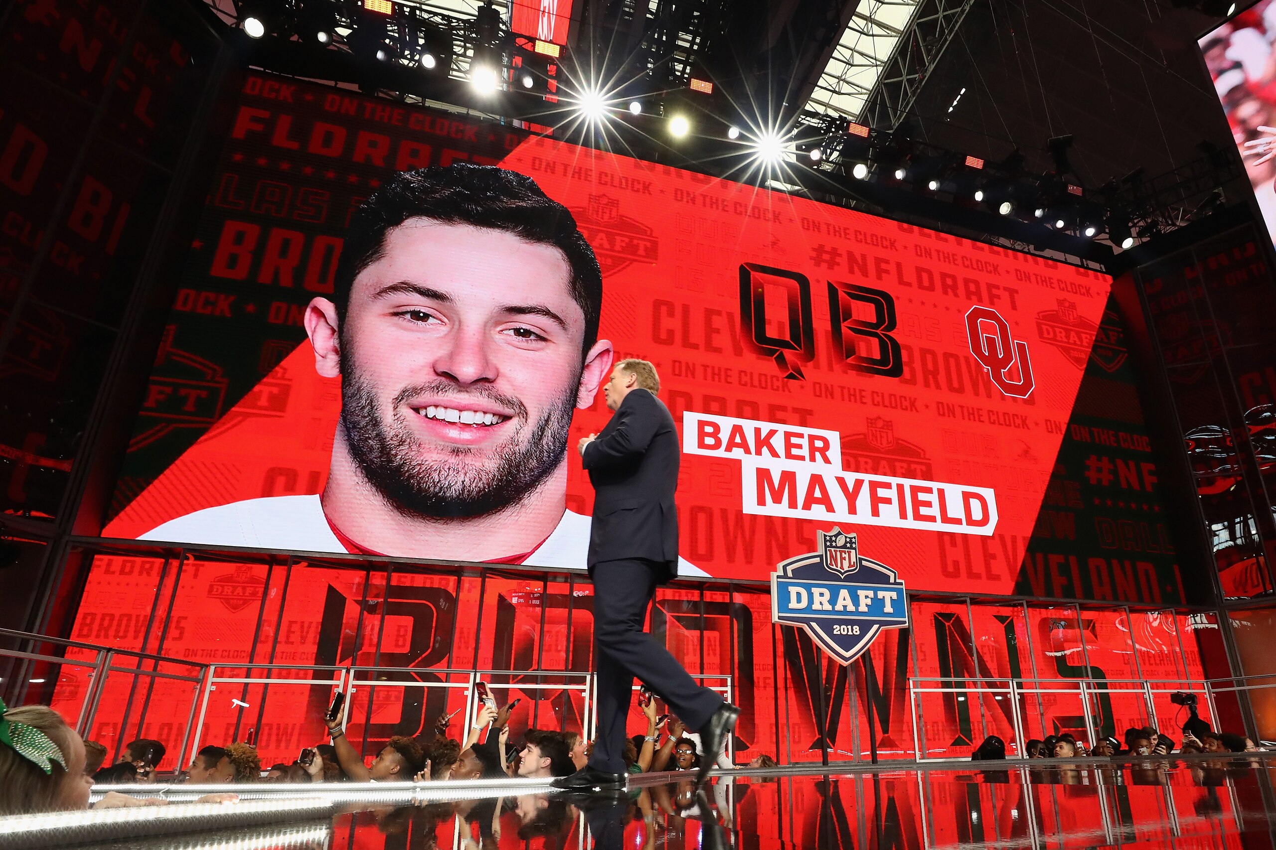 ARLINGTON, TX - APRIL 26:  NFL Commissioner Roger Goodell walks past a video board displaying an image of Baker Mayfield of Oklahoma after he was picked #1 overall by the Cleveland Browns during the first round of the 2018 NFL Draft at AT&T Stadium on Apr