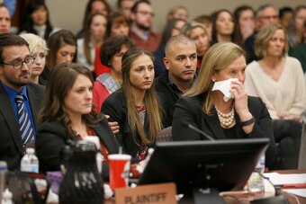 Kyle Stephens(C) and other people react as former Michigan State University and USA Gymnastics doctor Larry Nassar listens to impact statements during the sentencing phase in Ingham County Circuit Court on January 24, 2018 in Lansing, Michigan.
More than 