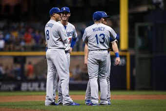 MILWAUKEE, WI - JULY 20:  Manny Machado #8, Cody Bellinger #35, Logan Forsythe #11, and Max Muncy #13 of the Los Angeles Dodgers meet in the eighth inning against the Milwaukee Brewers at Miller Park on July 20, 2018 in Milwaukee, Wisconsin. (Photo by Dyl