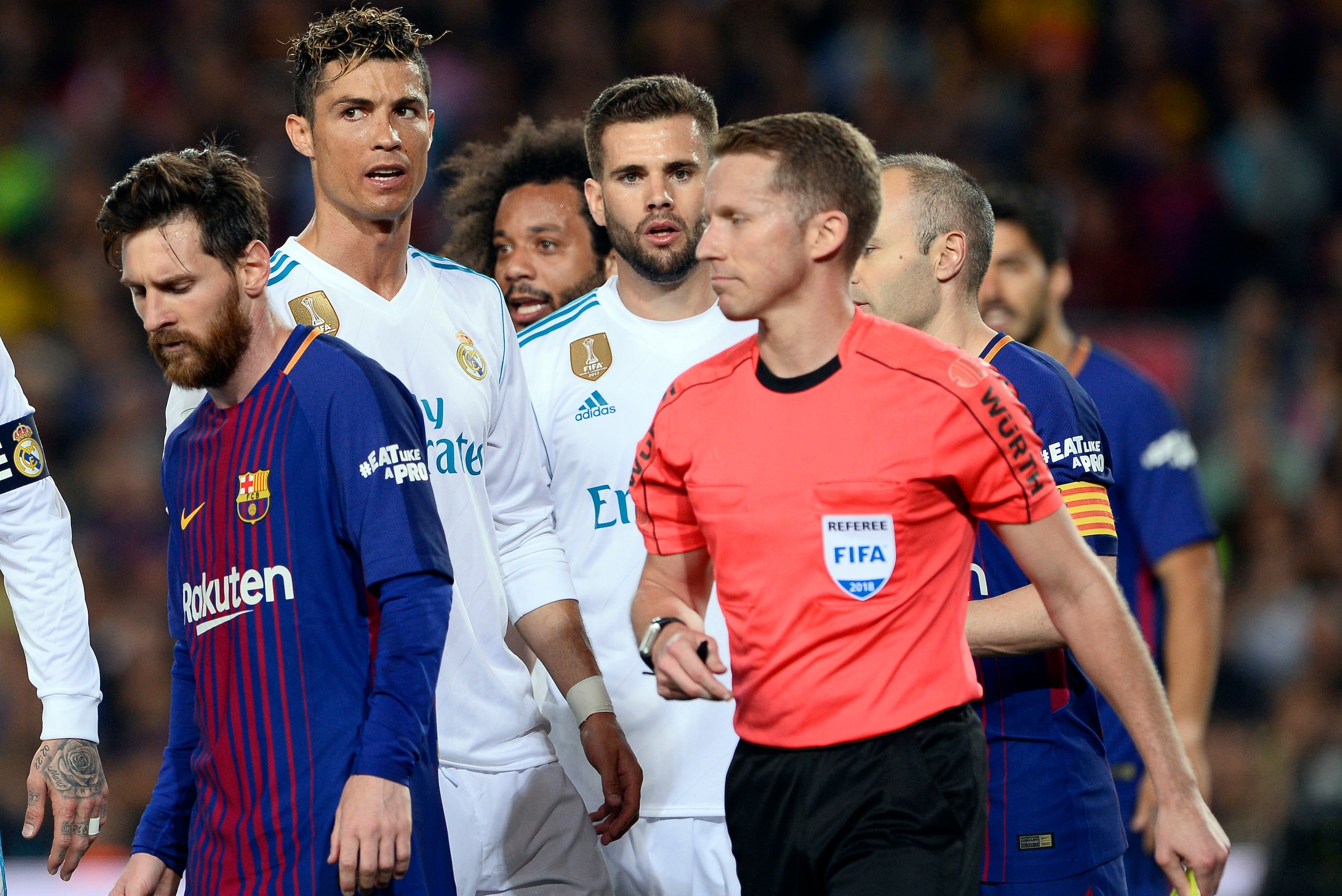 Spanish referee Hernandez Hernandez walks past Barcelona's Argentinian forward Lionel Messi (L) and Real Madrid's Portuguese forward Cristiano Ronaldo (2L) during the Spanish league football match between FC Barcelona and Real Madrid CF at the Camp Nou st