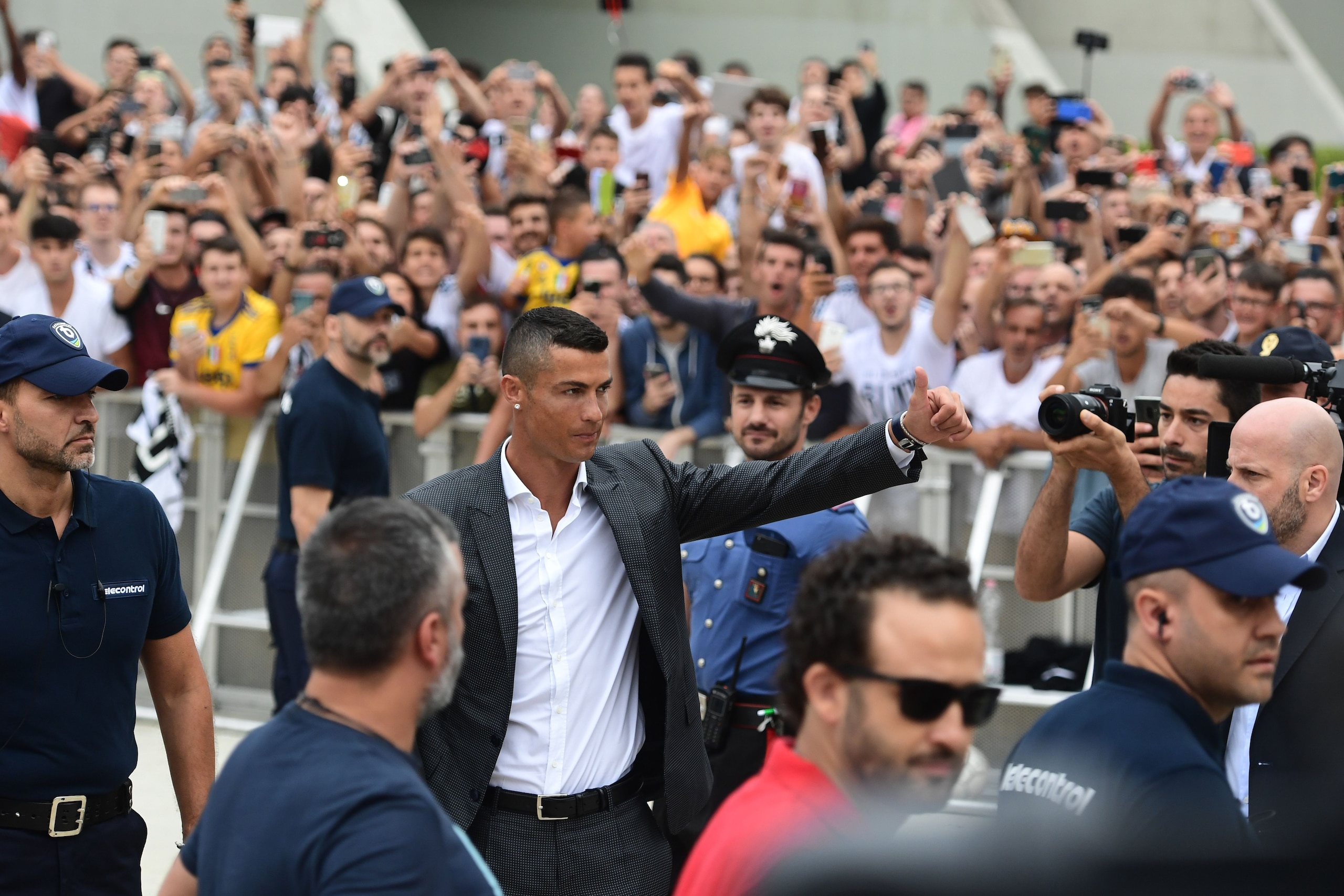 TOPSHOT - Cristiano Ronaldo waves to suppoters as he arrives on July 16, 2018 at the Juventus medical centre at the Alliance stadium in Turin. - A Turin hit by Cristiano Ronaldo fever awaits the striker as Juventus prepare to unveil the surprise signing, 