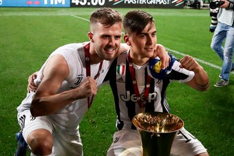 Juventus' forward from Argentina Paulo Dybala and Juventus midfielder from Italy Miralem Pjanic (L) pose with the trophy after winning the Italian Tim Cup (Coppa Italia) final Juventus vs AC Milan at the Olympic stadium on May 9, 2018 in Rome. - Juventus 