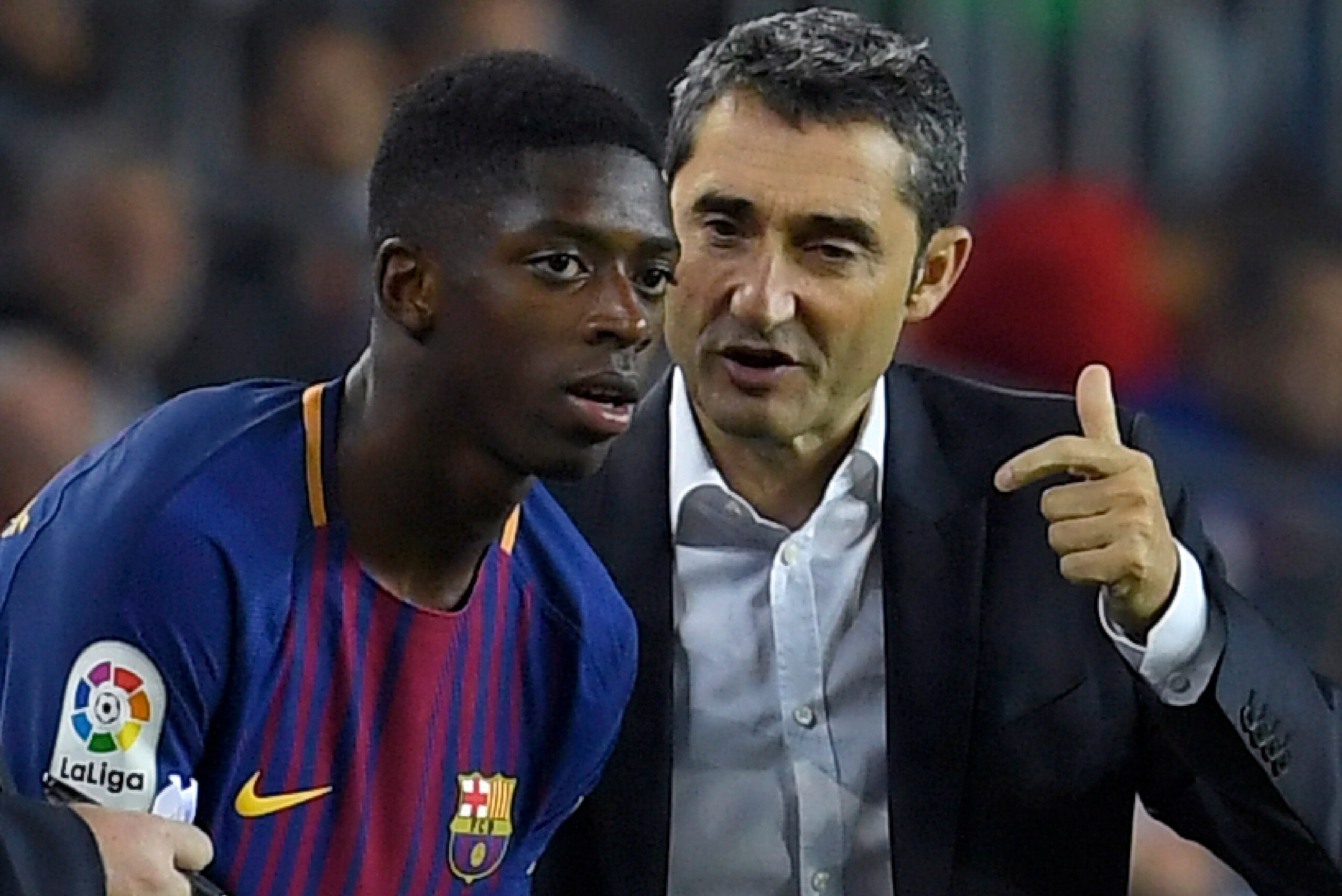 Barcelona's coach Ernesto Valverde (R) talks to Barcelona's French forward Ousmane Dembele during the Spanish Liga football match Barcelona vs Espanyol at the Camp Nou stadium in Barcelona on September 9, 2017. / AFP PHOTO / LLUIS GENE        (Photo credi