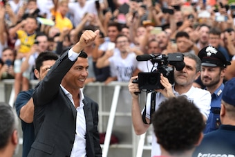 Portuguese footballer Cristiano Ronaldo waves to supporters as he arrives on July 16, 2018 at the Juventus medical centre at the Alliance stadium in Turin. - A Turin hit by Cristiano Ronaldo fever awaits the striker as Juventus prepare to unveil the surpr