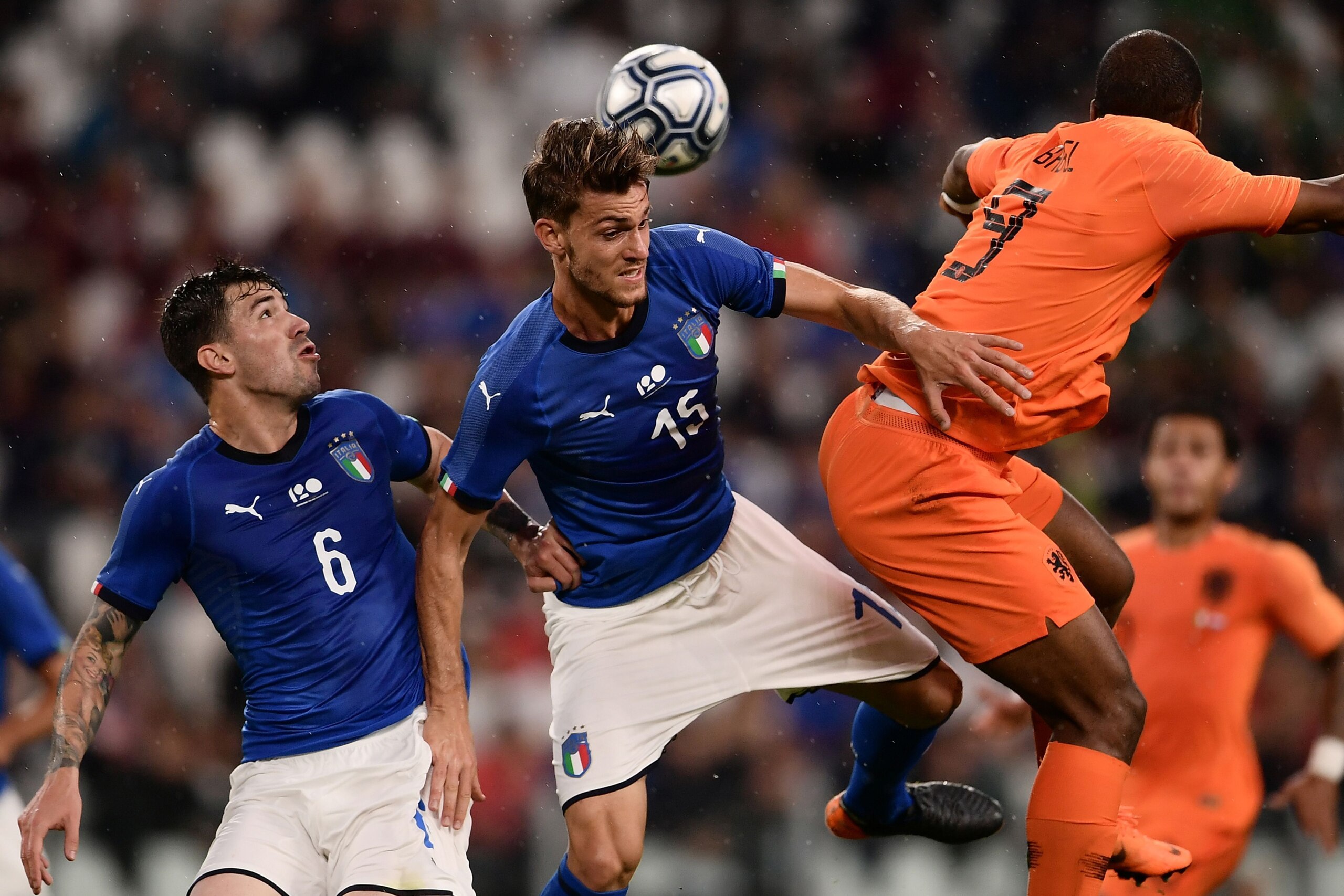 Italy's national team defender Daniele Rugani (C) jumps for the ball next to Netherlands' National team forward Ryan Babel (R) during the international friendly football match between Italy and the Netherlands at the Allianz Stadium in Turin on June 4, 20