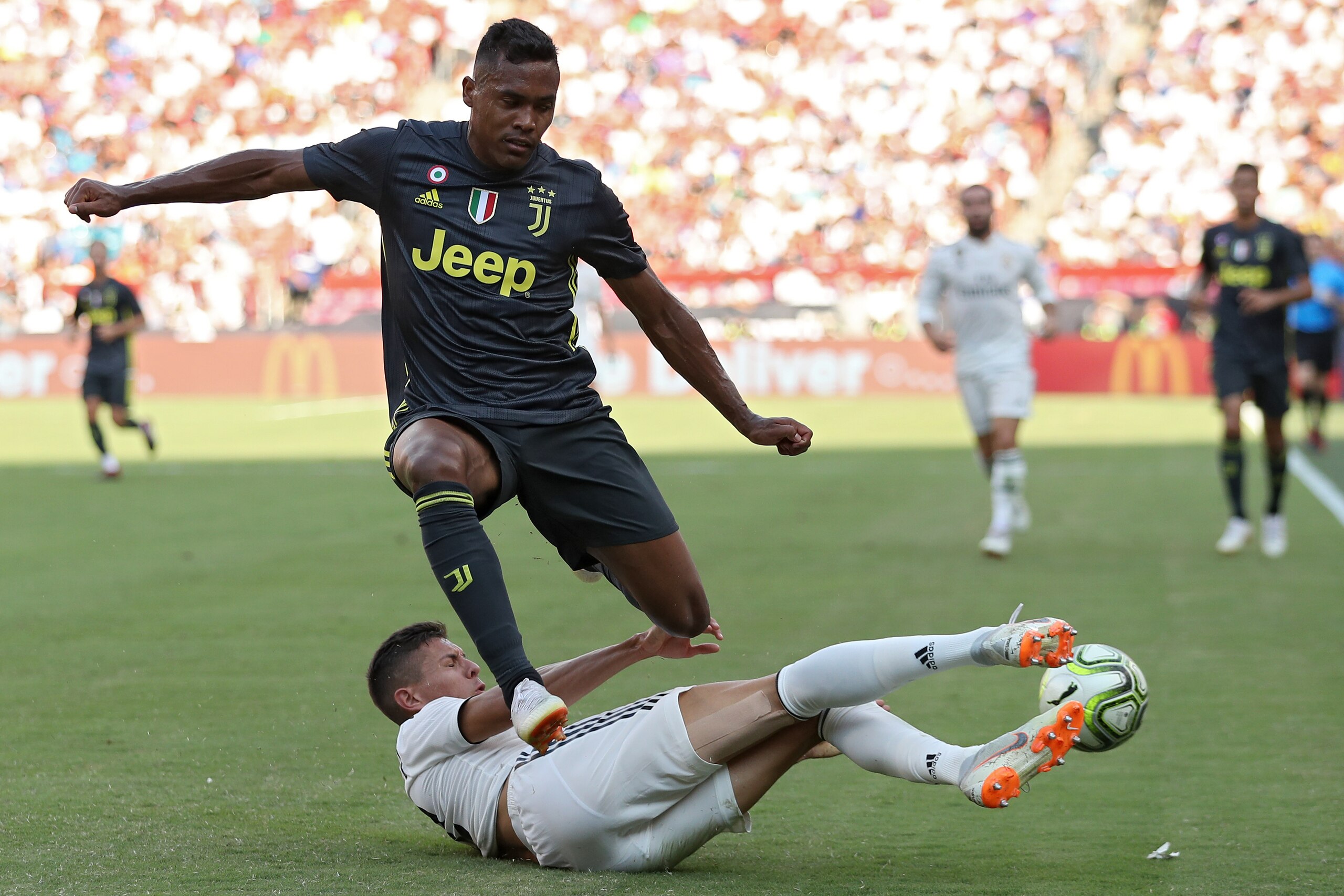 LANDOVER, MD - AUGUST 04: Alex Sandro #12 of Juventus is tackled by Javier Sanchez #32 of Real Madrid during the International Champions Cup at FedExField on August 4, 2018 in Landover, Maryland. (Photo by Patrick Smith/International Champions Cup/Getty I
