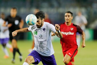 BUDAPEST, HUNGARY - AUGUST 2: (l-r) Mijusko Bojovic of Ujpest FC heads the ball in front of Wissam Ben Yedder of Sevilla FC during the UEFA Europa League Second Qualifying Round 2nd Leg match between Ujpest FC and Sevilla FC at Ferenc Szusza Stadium on Au
