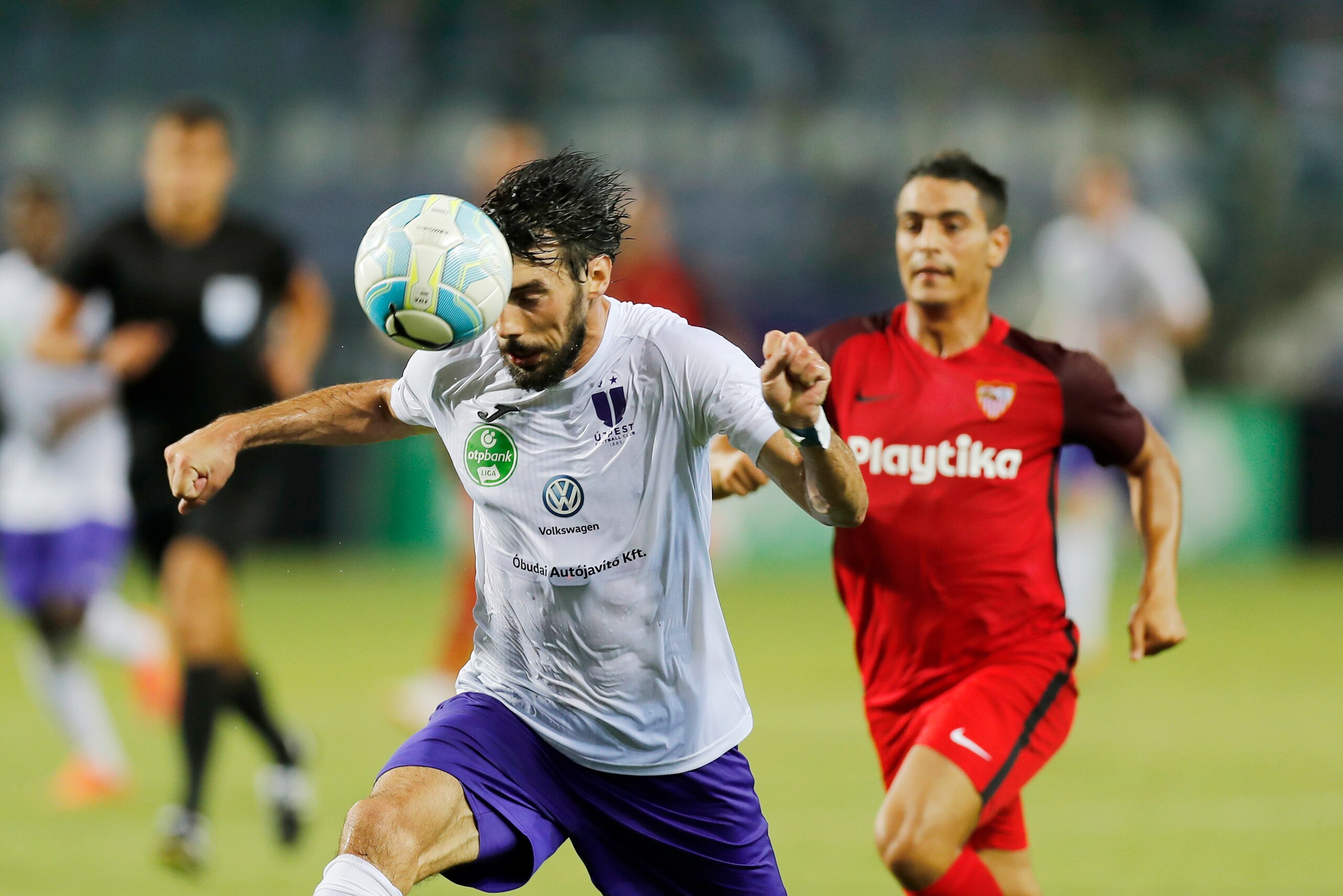 BUDAPEST, HUNGARY - AUGUST 2: (l-r) Mijusko Bojovic of Ujpest FC heads the ball in front of Wissam Ben Yedder of Sevilla FC during the UEFA Europa League Second Qualifying Round 2nd Leg match between Ujpest FC and Sevilla FC at Ferenc Szusza Stadium on Au